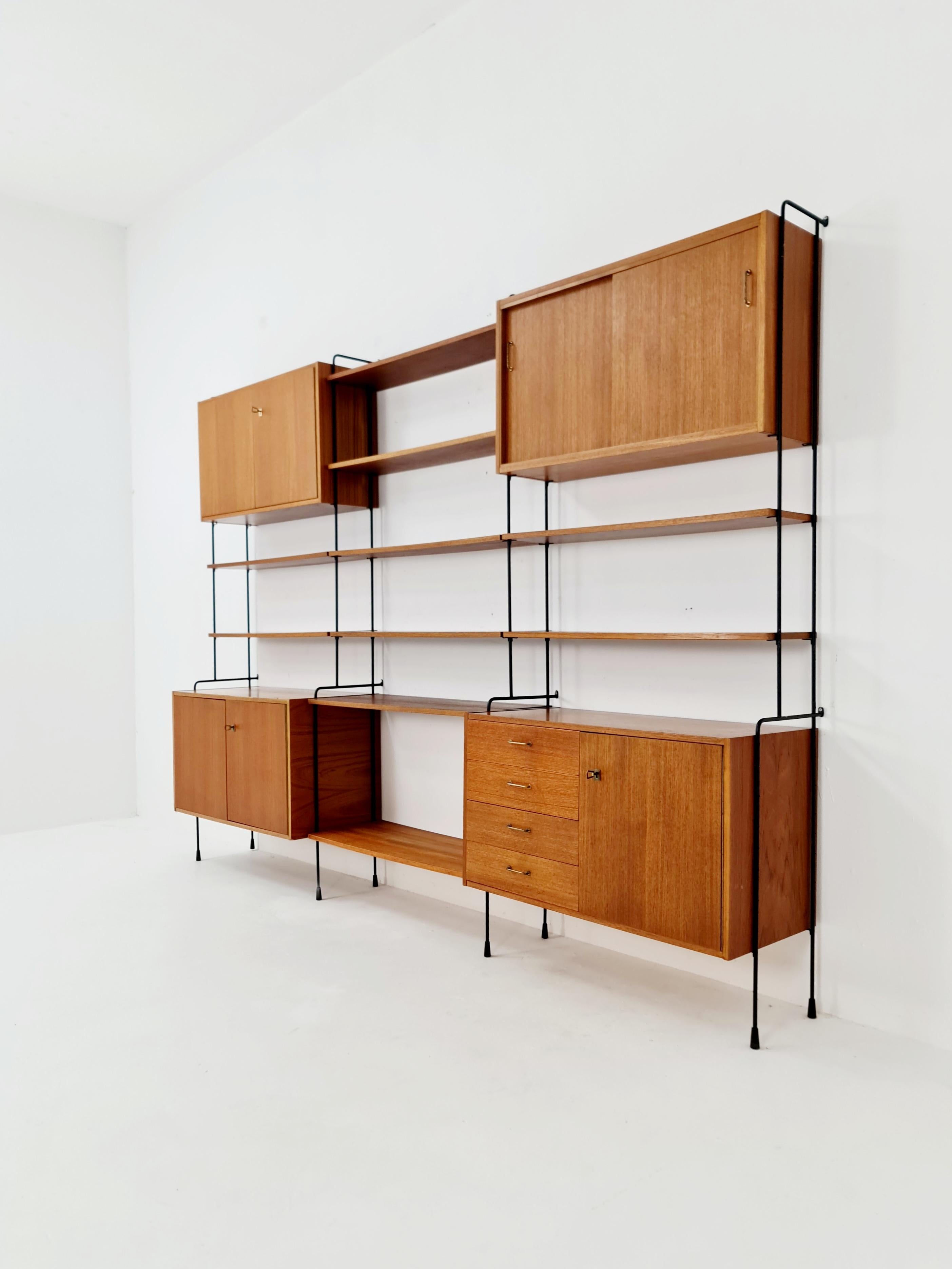 Mid century Teakholzregal von Hilker für Omnia, Deutschland 1960er Jahre

Designed by Hilker -- Die einzelnen Elemente und Regale können auf verschiedene Weise konfiguriert werden. 

 Der Rahmen wird mit Schrauben an der Wand befestigt - mit