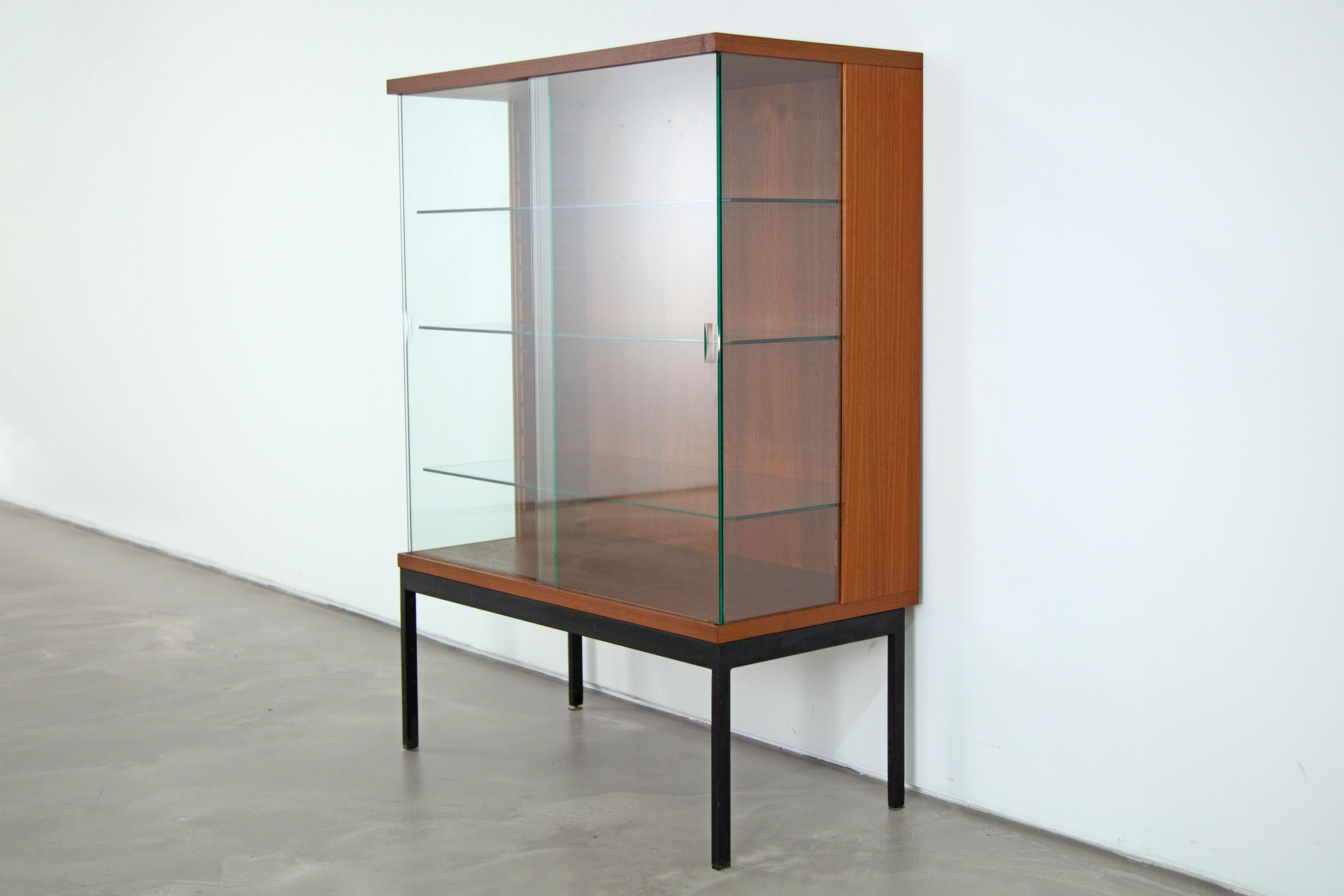 A rare piece of furniture from the early 1960s. The display is veneered with teak and features glass sliding doors.