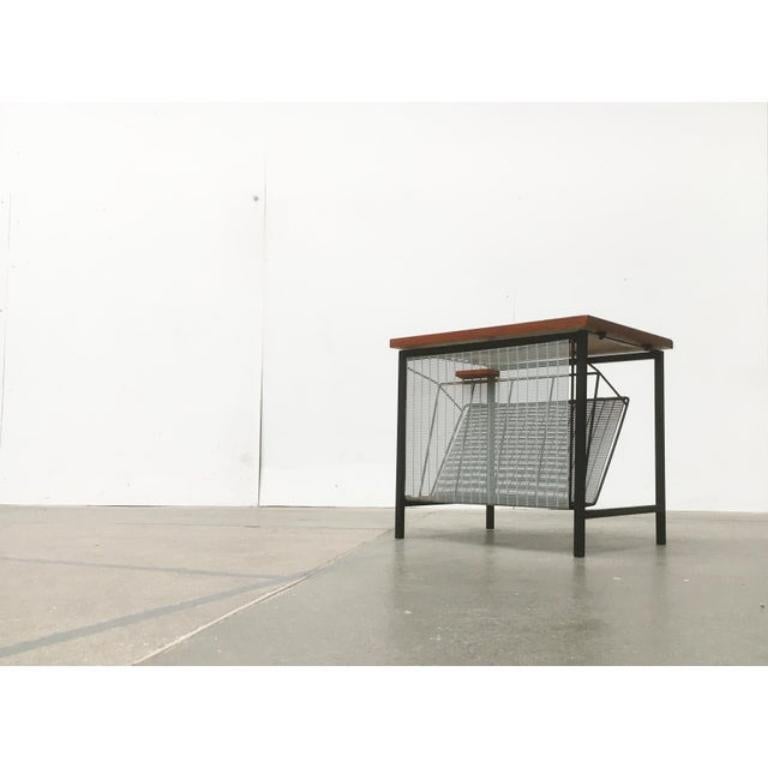 Table d'appoint fonctionnelle du milieu du siècle dernier avec porte-journaux.

Cette petite table d'appoint est à la fois une table et un porte-revues. L'avant peut être incliné vers l'avant d'un simple coup de poignet. La pile de magazines
