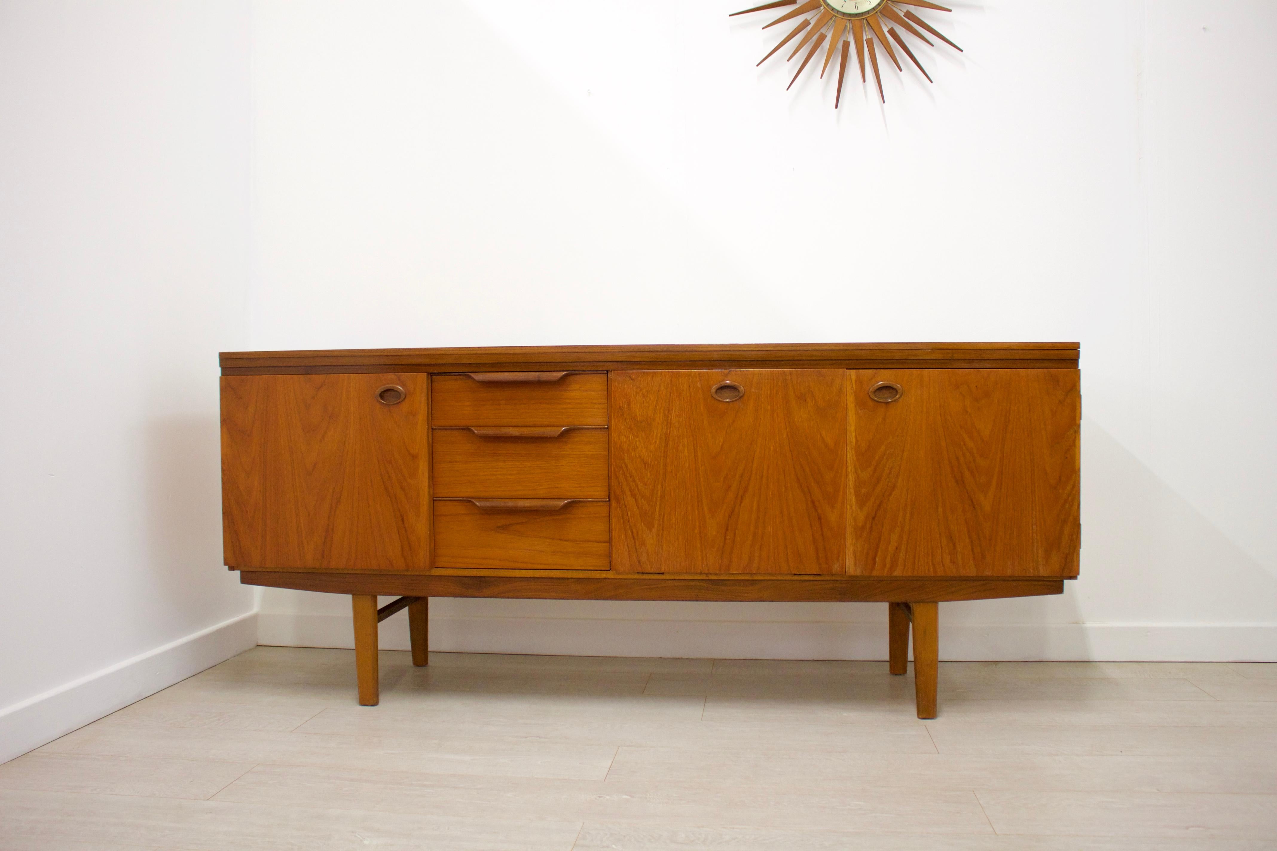 -Mid-Century Modern sideboard
- Made of teak & teak veneer
- Features 2 cupboards with shelves, a pull-down drinks cabinet and 3 drawers.