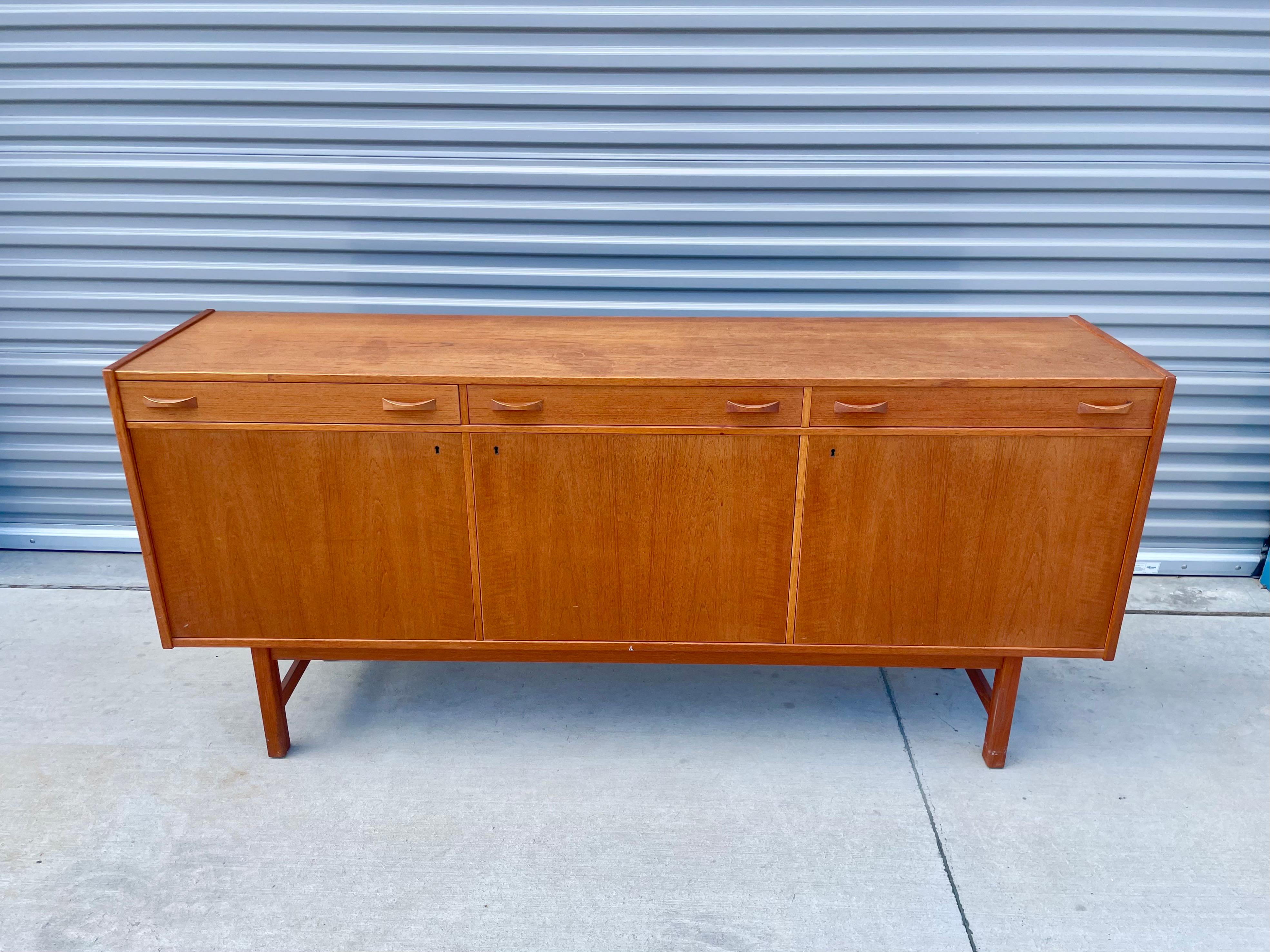 Stunning mid-century teak sideboard designed by Tage Olofsson for Ulferts Møbler in Sweden circa 1960s. This credenza features a solid teak frame with an excellent color tone and a beautiful grain pattern, creating a refined and elegant look. The