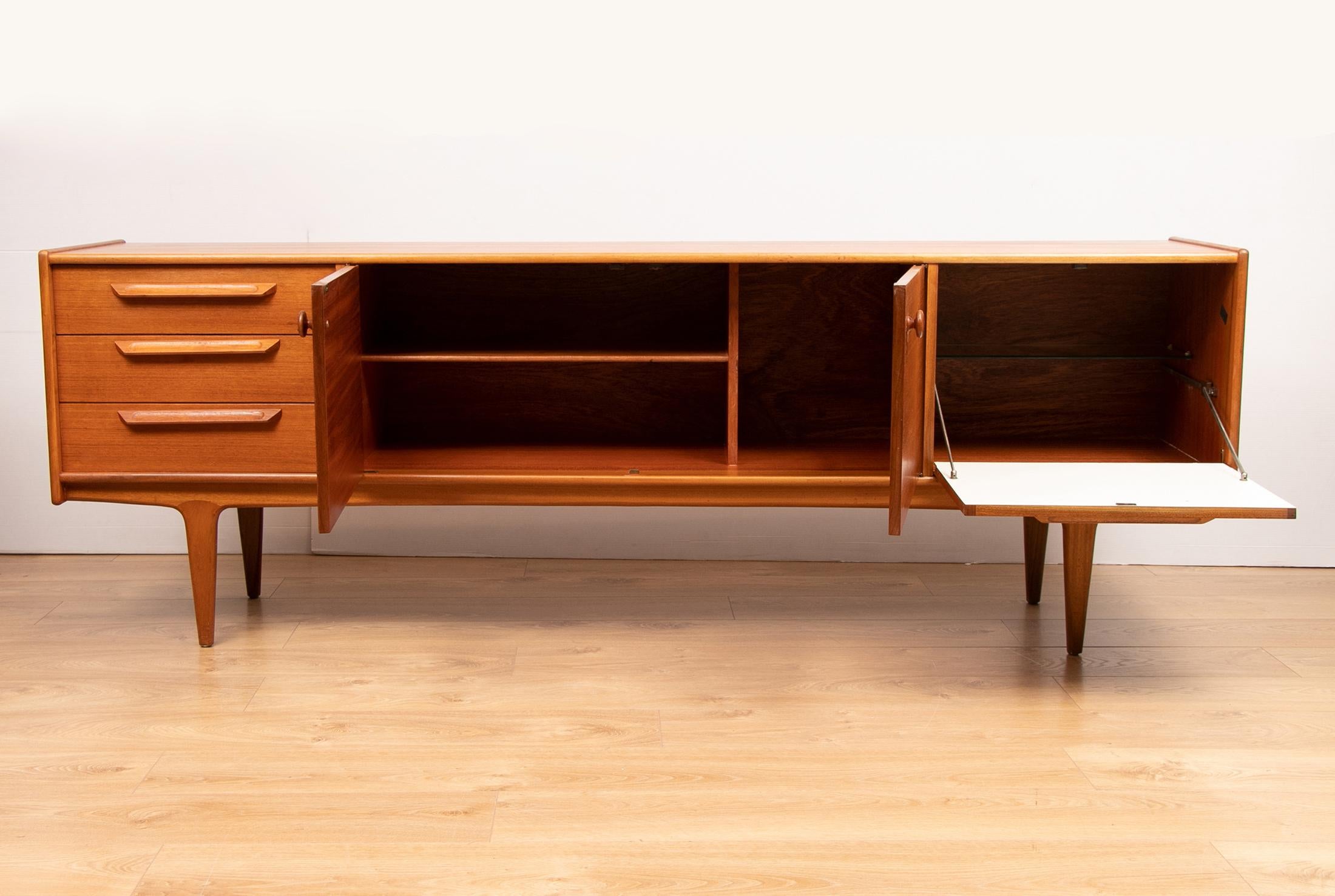 A midcentury teak sideboard designed by A. Younger Ltd, Scotland, circa 1960. The sideboard contains three drawers and three storage compartments. Very good condition with minor signs of use.