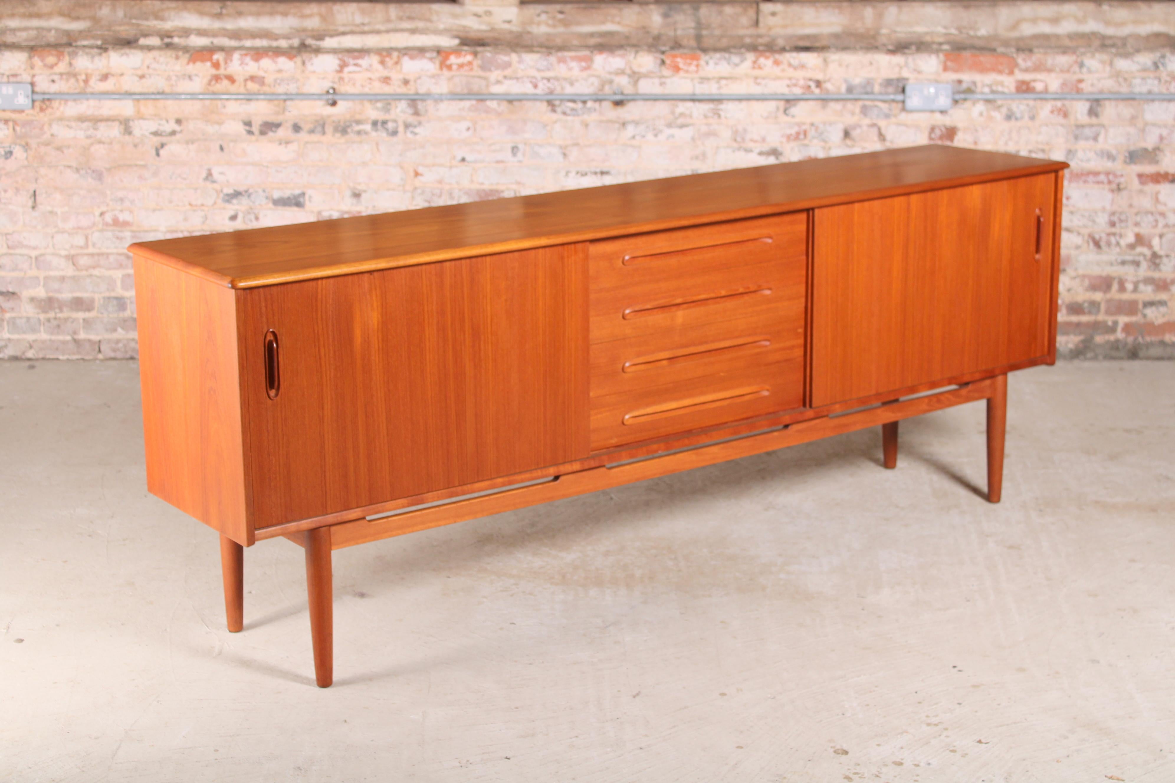 Mid-century teak sideboard by Nils Jonsson for Troeds, Sweden, circa 1960s. 2 cabinets with sliding doors and 4 drawers. Top drawer is a cutlery drawer with a removable tray

Dimensions: 222 W x 45.5 D x 79.5 H cm.