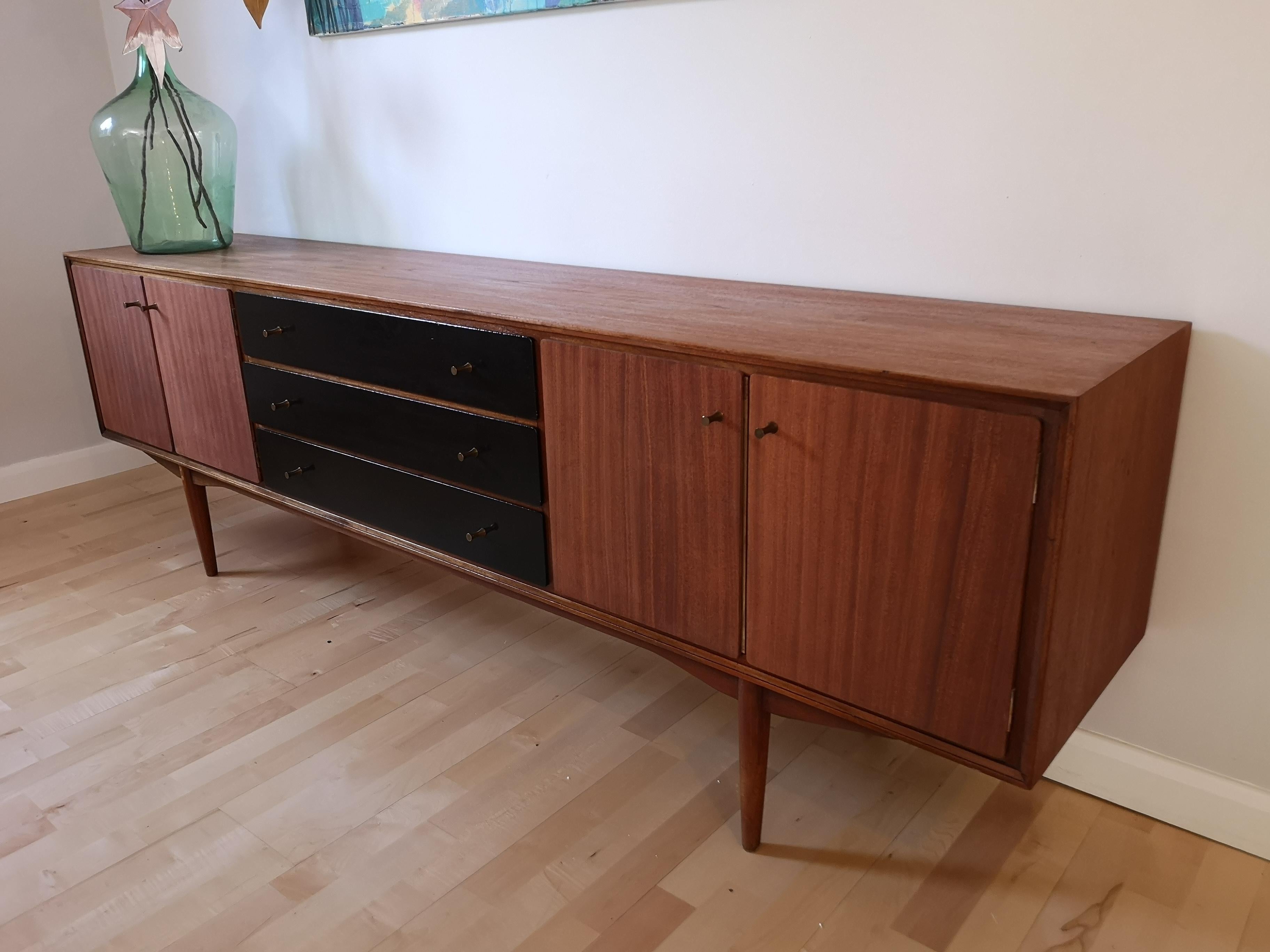 A stunning large 225cm/7ft3 midcentury teak sideboard credenza by Everest of Long Eaton, England. Originally purchased from Heal's in 1959. The doors and drawers were originally painted white. Stripping off the paint revealed lovely teak grain on