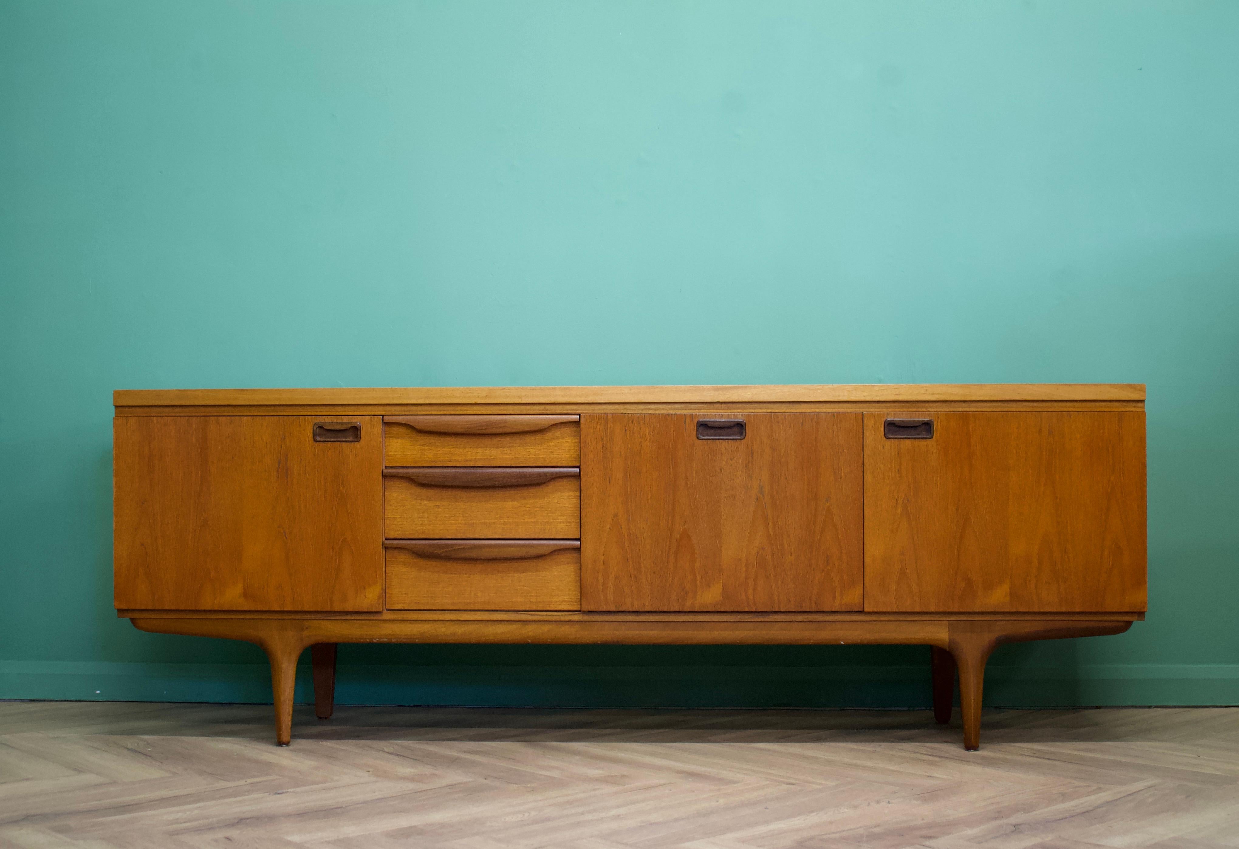 - Mid-Century Modern sideboard
- Features two cupboards, a pull down drinks cabinet and 3 drawers
- There's also a sliding compartment to the drinks cabinet
- Manufactured by Greaves & Thomas in the UK
- Made from teak and teak veneer.