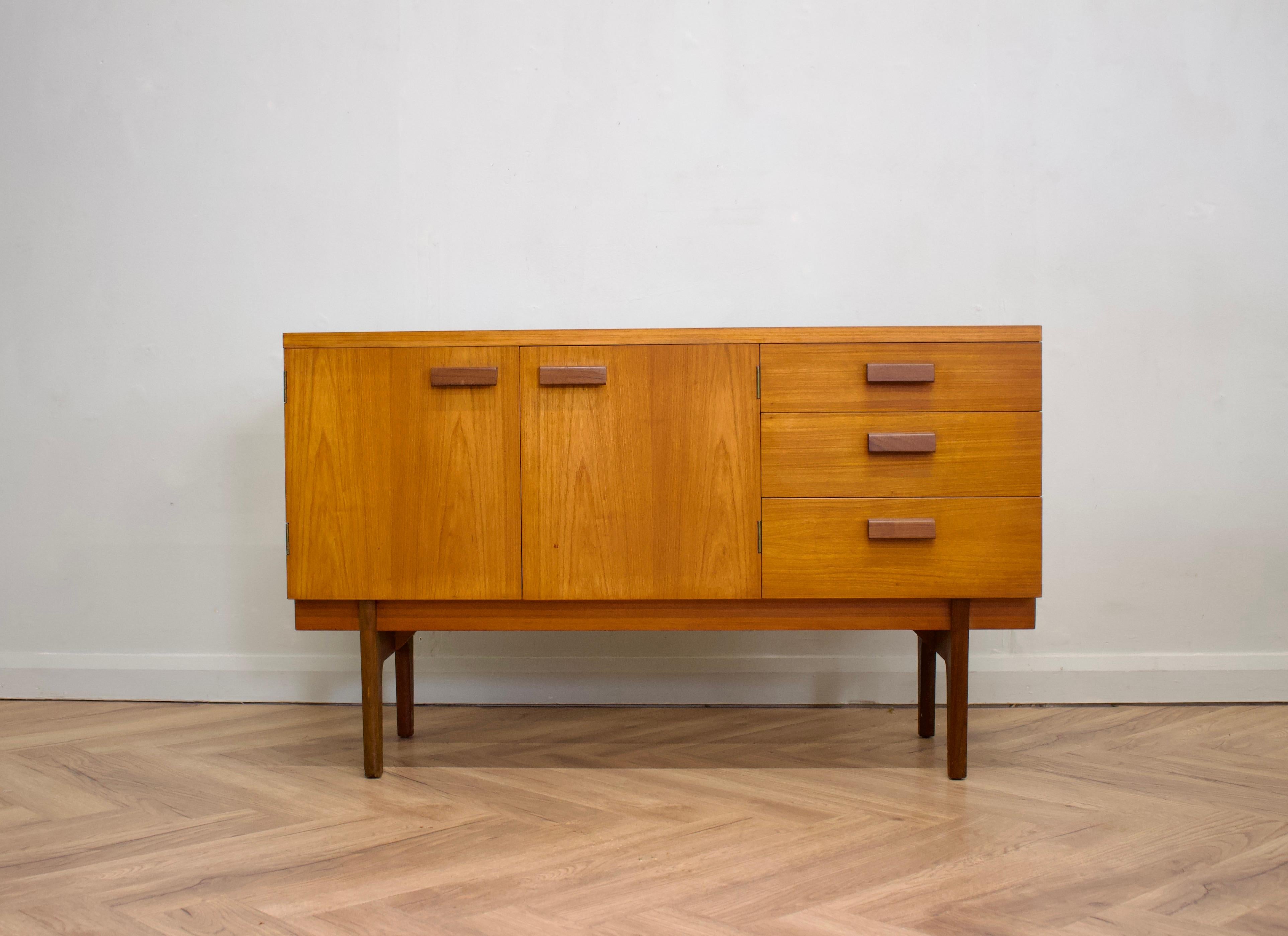 - Mid century modern sideboard.
- Featuring a cupboard and three drawers
- Manufactured in the UK by Uniflex
- Made from teak and teak veneer.