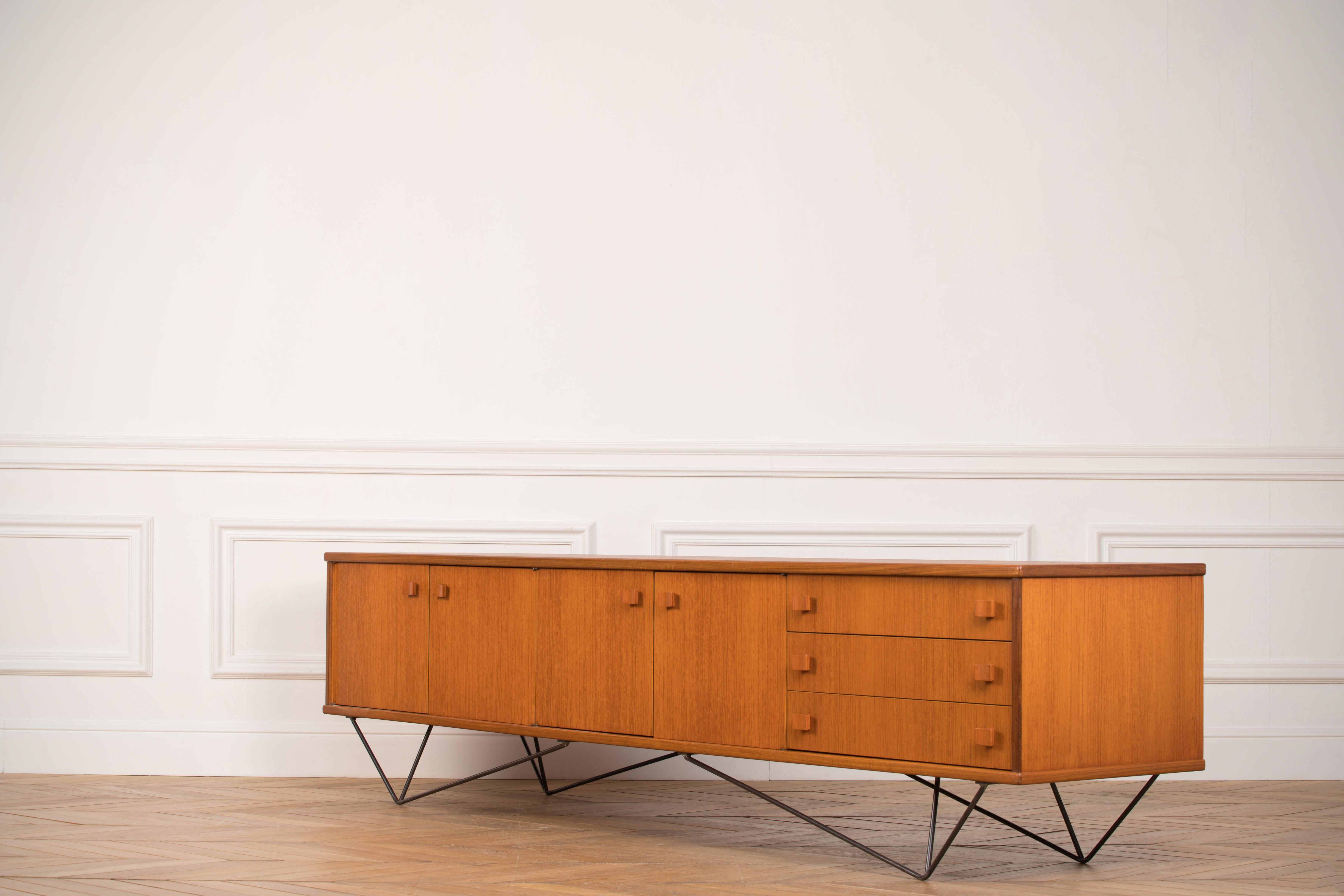 Midcentury teak sideboard from the 1960s. It is a shining example of the form and function synonymous with Danish furniture of this era. It has is all; well-built, great design and heaviness. Three large drawers and four doors hiding storage space.