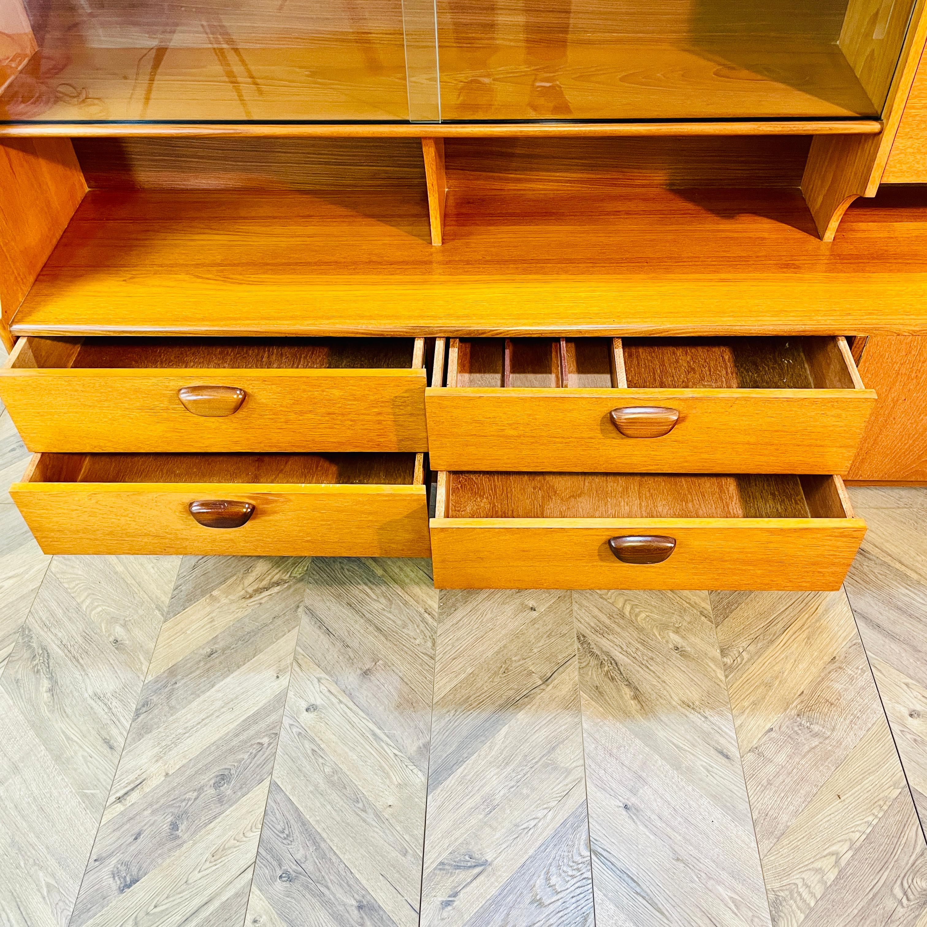 Ein super stilvolles, Mid Century, langes Teak Sideboard / Highboard vom britischen Möbelhersteller: Portwood. circa 1970er Jahre

Der Schrank bietet viel Stauraum, mit vier Schubladen (eine davon mit Besteckfach), einem Schrankfach, einem