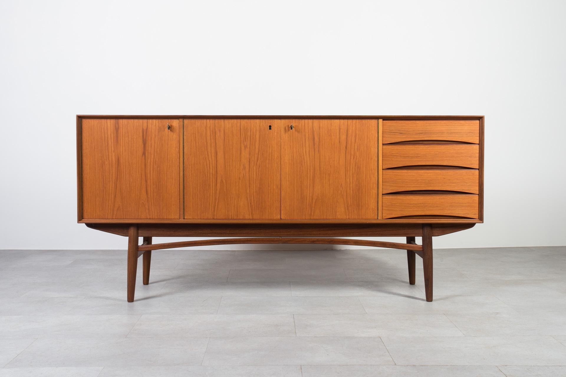Questa credenza in teak proviene dalla Norvegia ed è stata realizzata intorno agli anni Sessanta. Molto probabilmente si tratta di uno dei design di Gustav Bahus. Presenta tre sezioni di stoccaggio, due con ripiani e una con quattro pratici cassetti