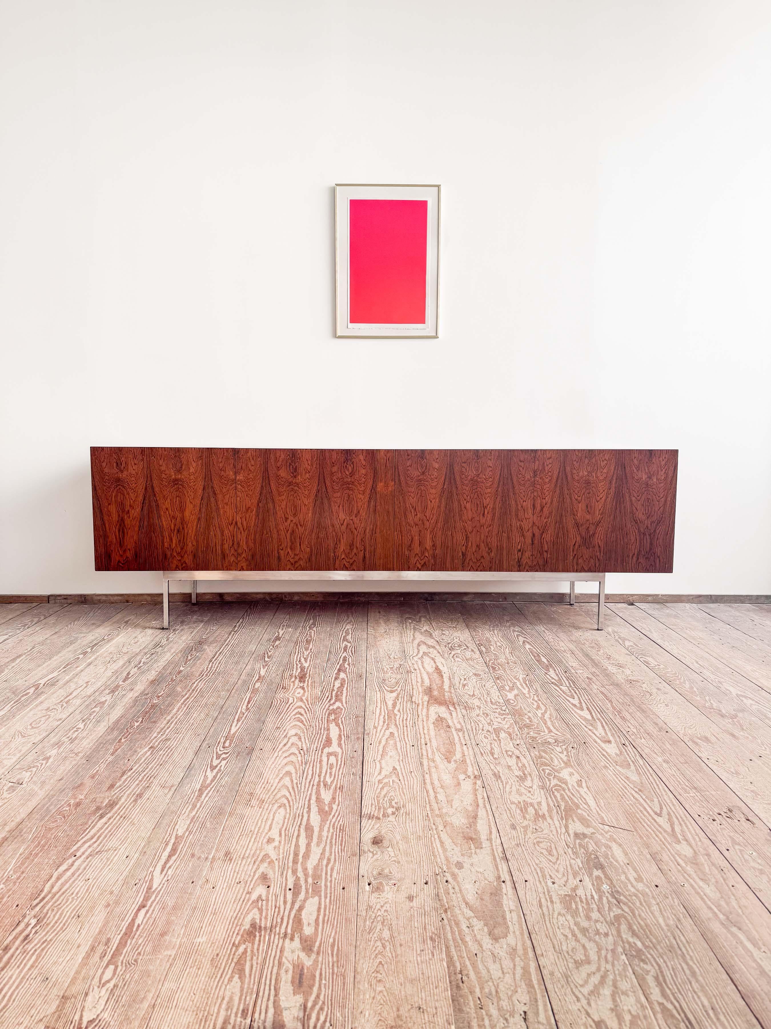 Dimensions: 248 x 56 x 80 cm (W x D x H)
Dimensions: approx. 97.6 x 22 x 31.5 in

Elegant Dieter Wäckerlin sideboard in dark veneer with a dramatic grain. The minimalist sideboard sits on a chrome metal base. The interior comes in maple veneer. The