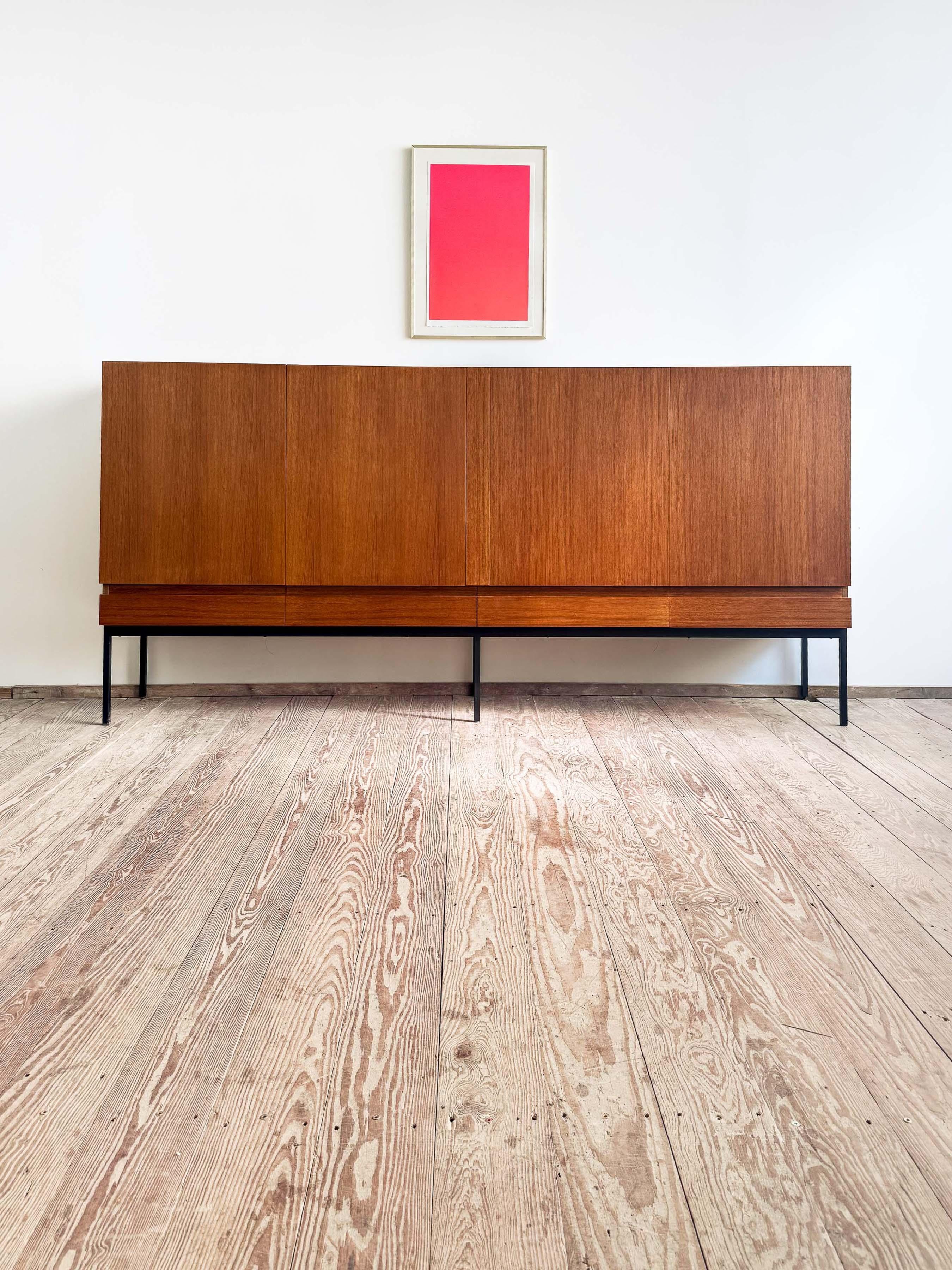 Dimensions: 248 x 43 x 119 cm (L x D x H)
Dimensions: approx. 97.6 x 16.9 x 46.9 in

Elegant Dieter Wäckerlin sideboard with black metal base. Inlay made out of maple. Outside is veneered in teak. Lots of storage space with four drawers and many