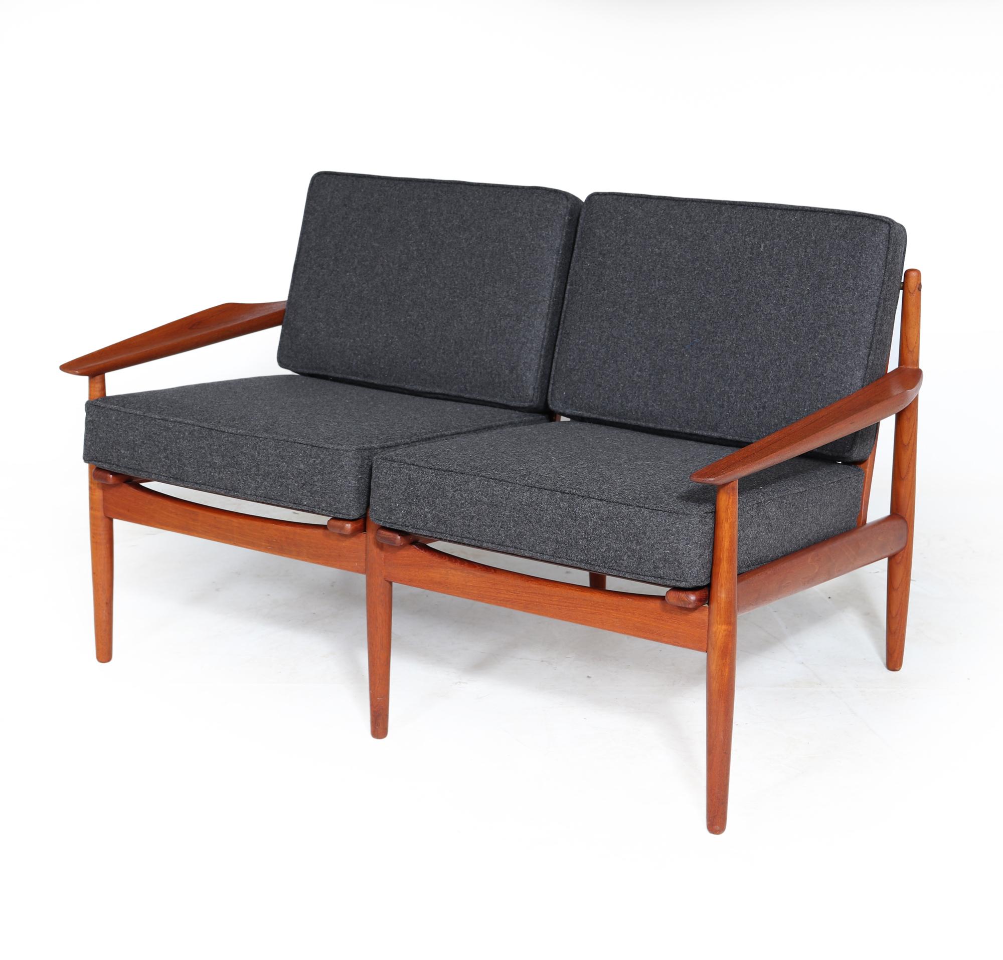 An early midcentury teak framed sofa designed by Arne Vodder and produced by Glostrup in the 1950s in Denmark, the Sofa have beautifully shaped and sculpted teak armrests and solid teak framework with wire sprung seat and back, The sofa has been