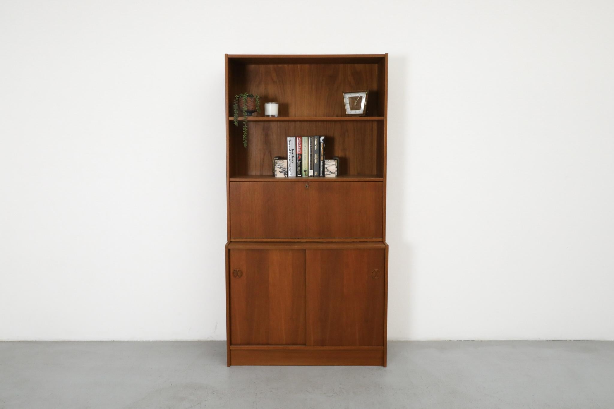 Ein vielseitiges und elegantes Bücherregal aus der Mitte des Jahrhunderts, das der Brouer Møbelfabrik zugeschrieben wird und aus warm getöntem Teakholz gefertigt ist. Dieses multifunktionale Möbelstück besteht aus zwei verschiedenen Teilen, die