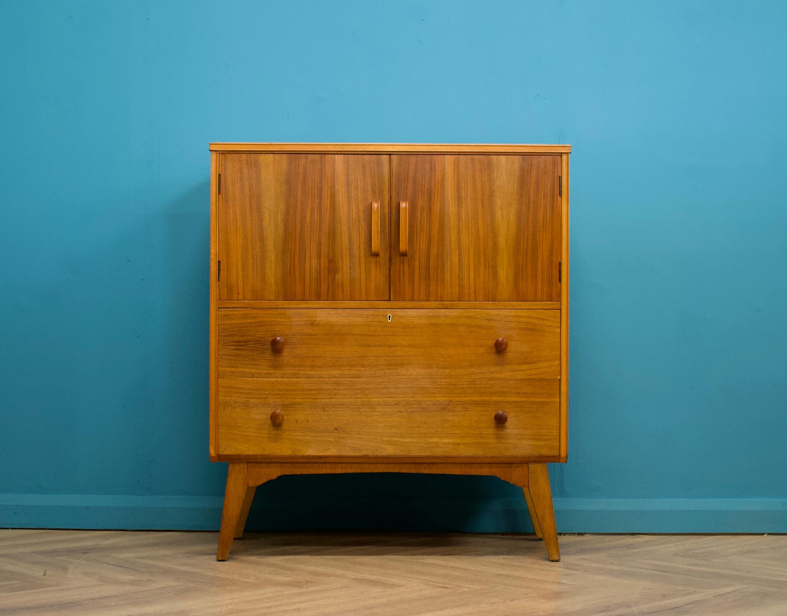 A mid century teak tallboy from Golden Key
Featuring two drawers and a cupboard with a shelf