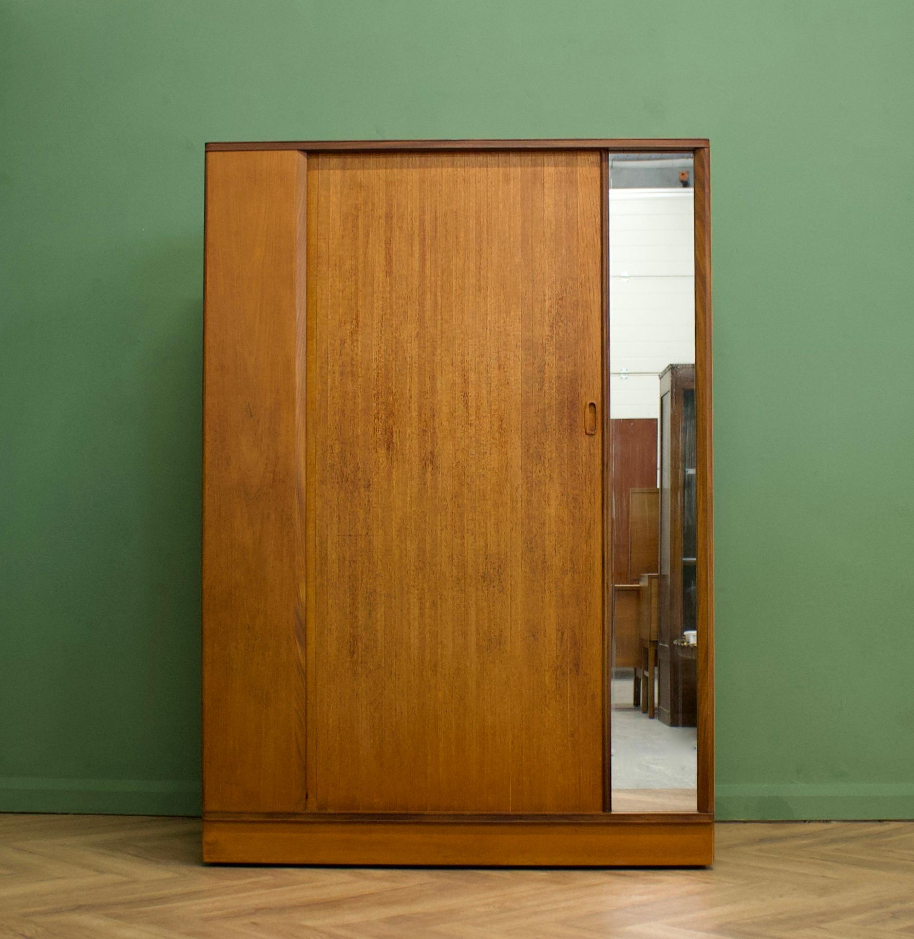 A freestanding teak wardrobe from Austinsuite - standing castors
These Austinsuite wardrobes have a unique design feature of a sliding tambour door - which runs very smooth
There's an external full length mirror - internally there's a hanging rail