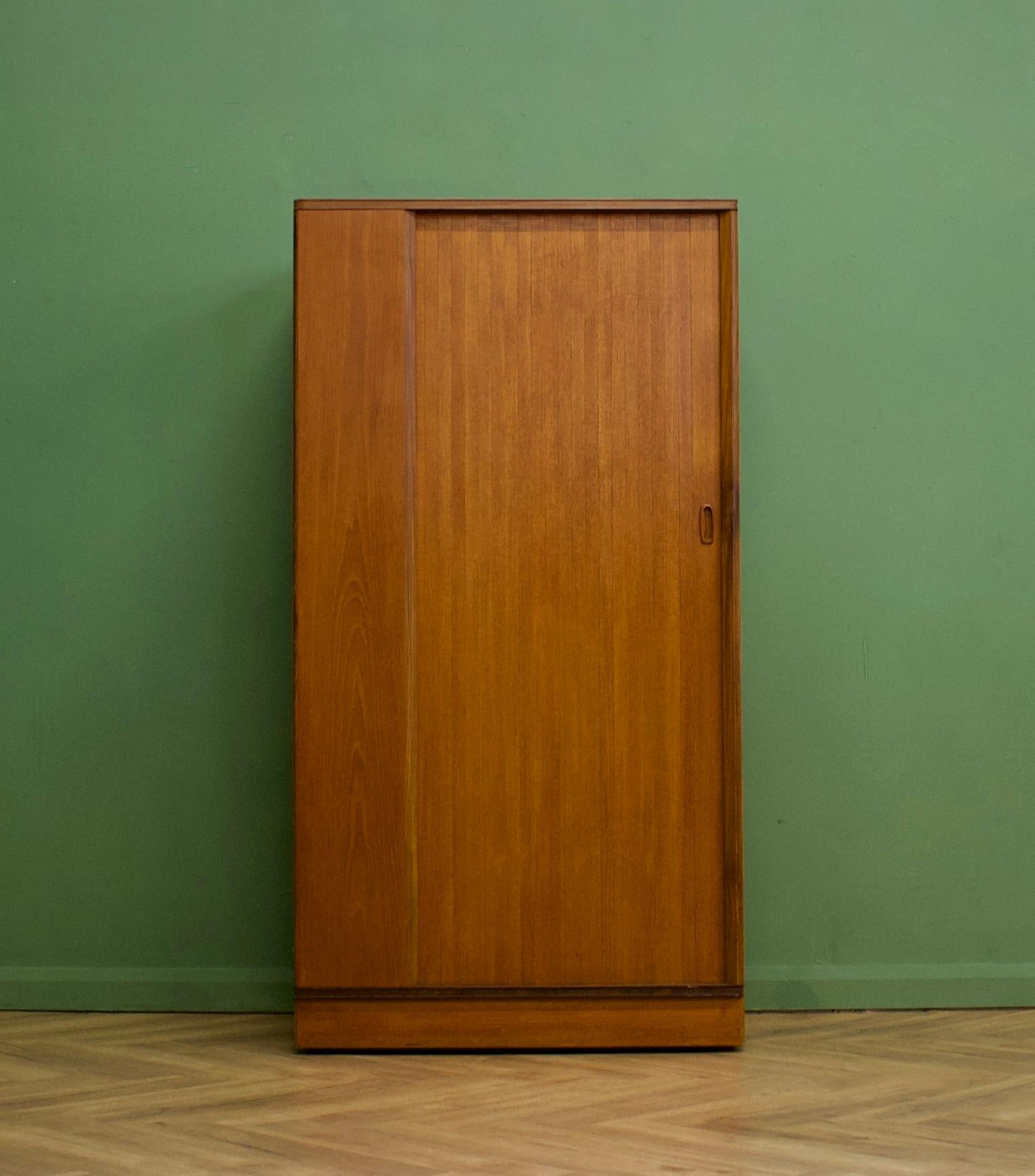 A freestanding teak wardrobe from Austinsuite - standing castors
These Austinsuite wardrobes have a unique design feature of a sliding tambour door - which runs very smooth
Internally there's a hanging rail and shelves
This piece has been cleaned