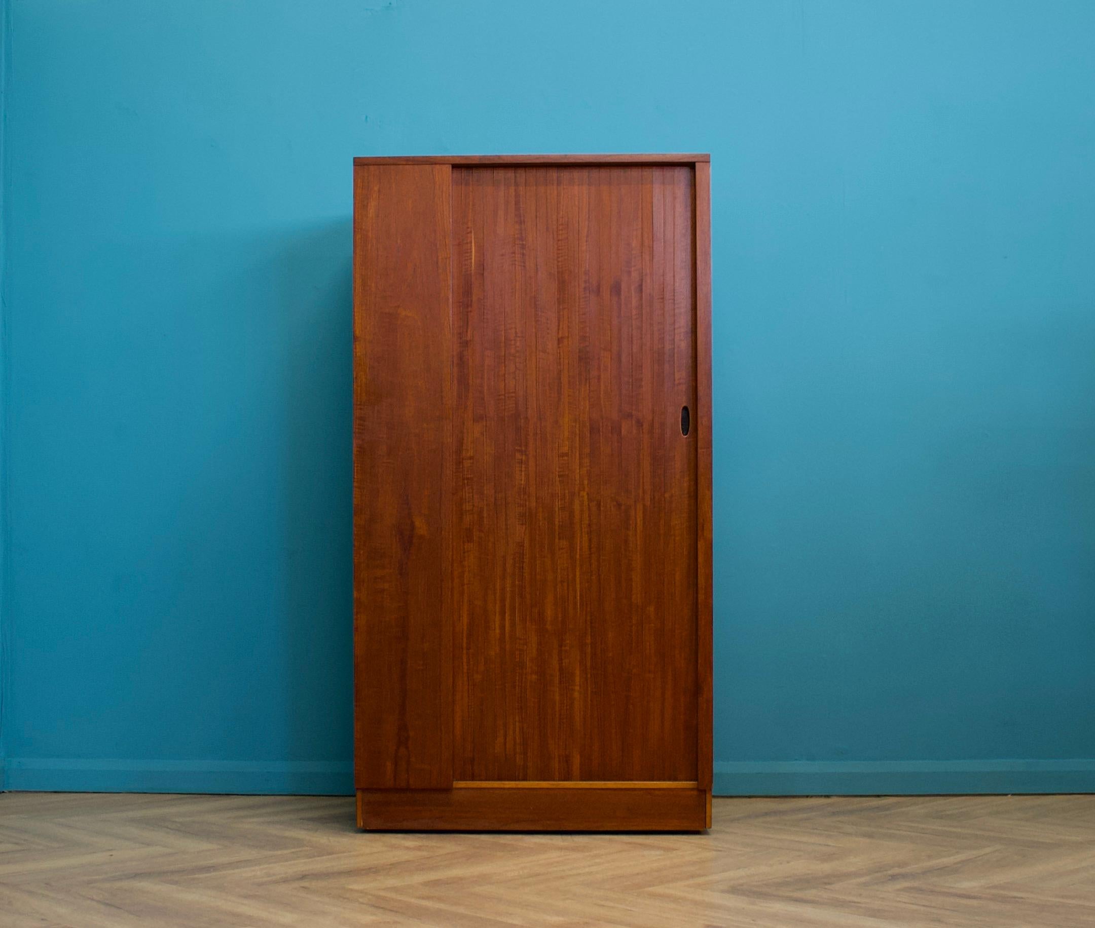A freestanding teak wardrobe from Austinsuite - standing castors
These Austinsuite wardrobes have a unique design feature of a sliding tambour door - which runs very smooth
Internally there's a hanging rail and shelves
This piece has been cleaned