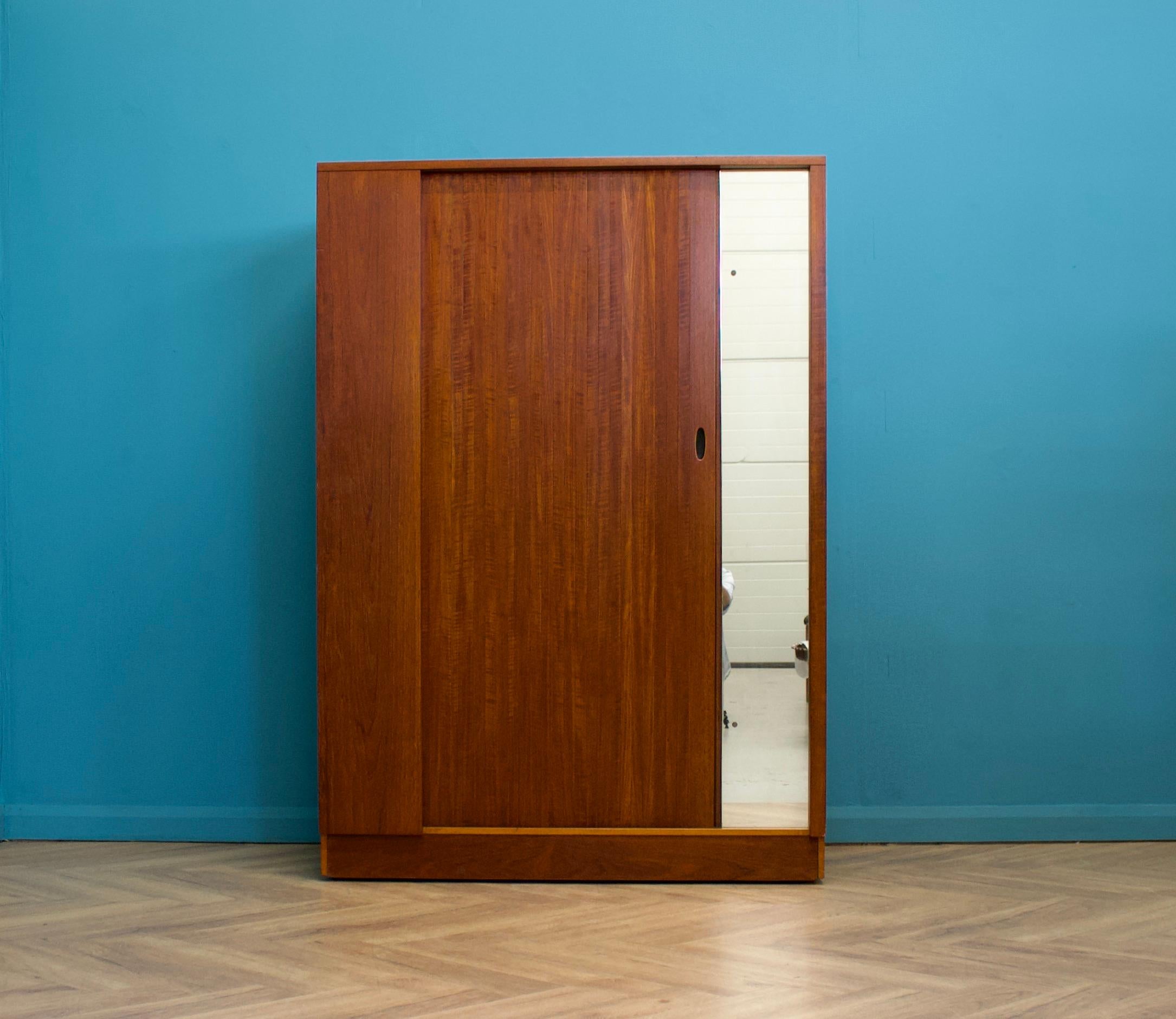 A freestanding teak wardrobe from Austinsuite - standing castors
These Austinsuite wardrobes have a unique design feature of a sliding tambour door - which runs very smooth
There's an external full length mirror - internally there's a hanging rail