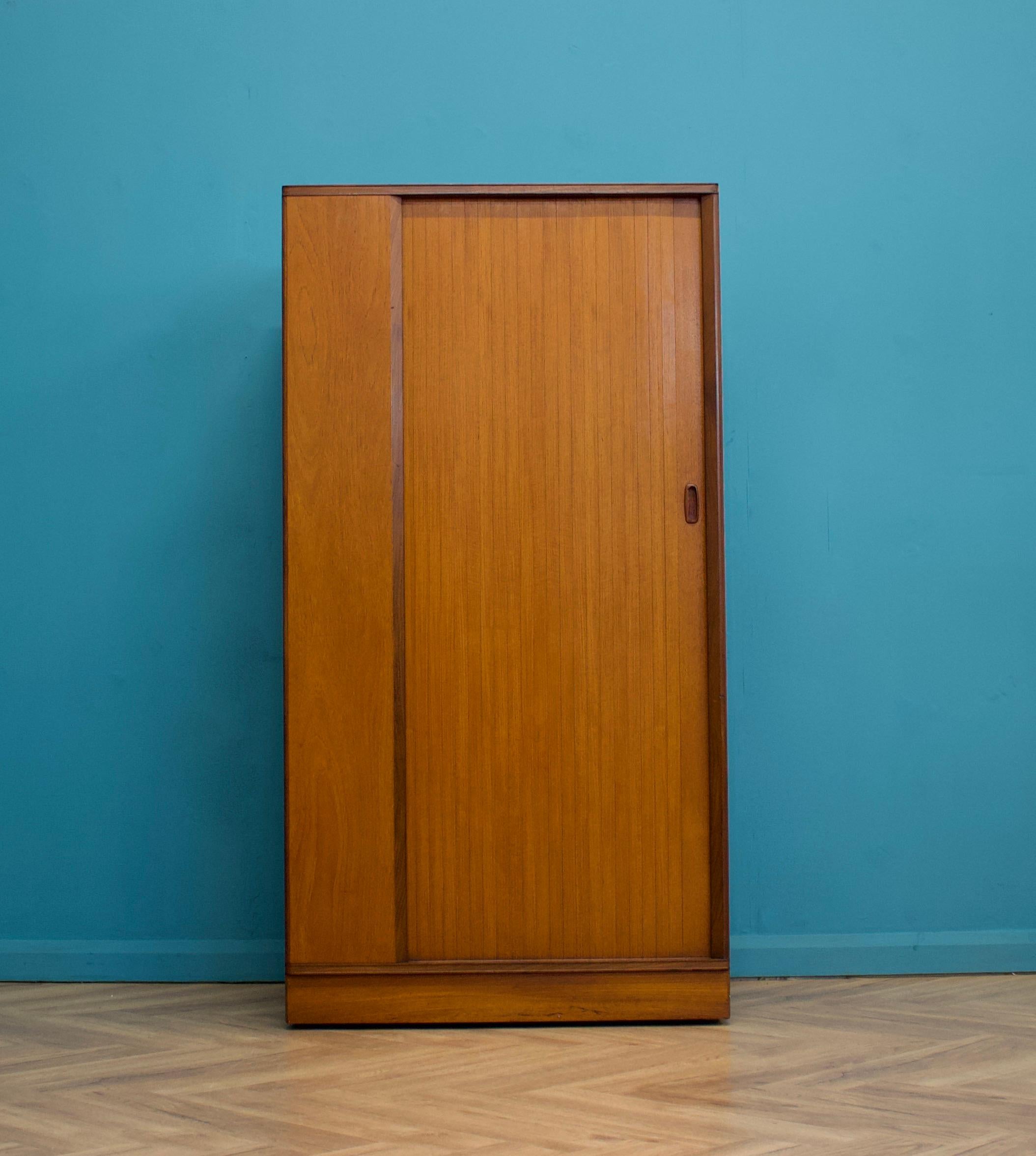 A freestanding teak wardrobe from Austinsuite - standing castors
These Austinsuite wardrobes have a unique design feature of a sliding tambour door - which runs very smooth
Internally there's a hanging rail and shelves
This piece has been cleaned
