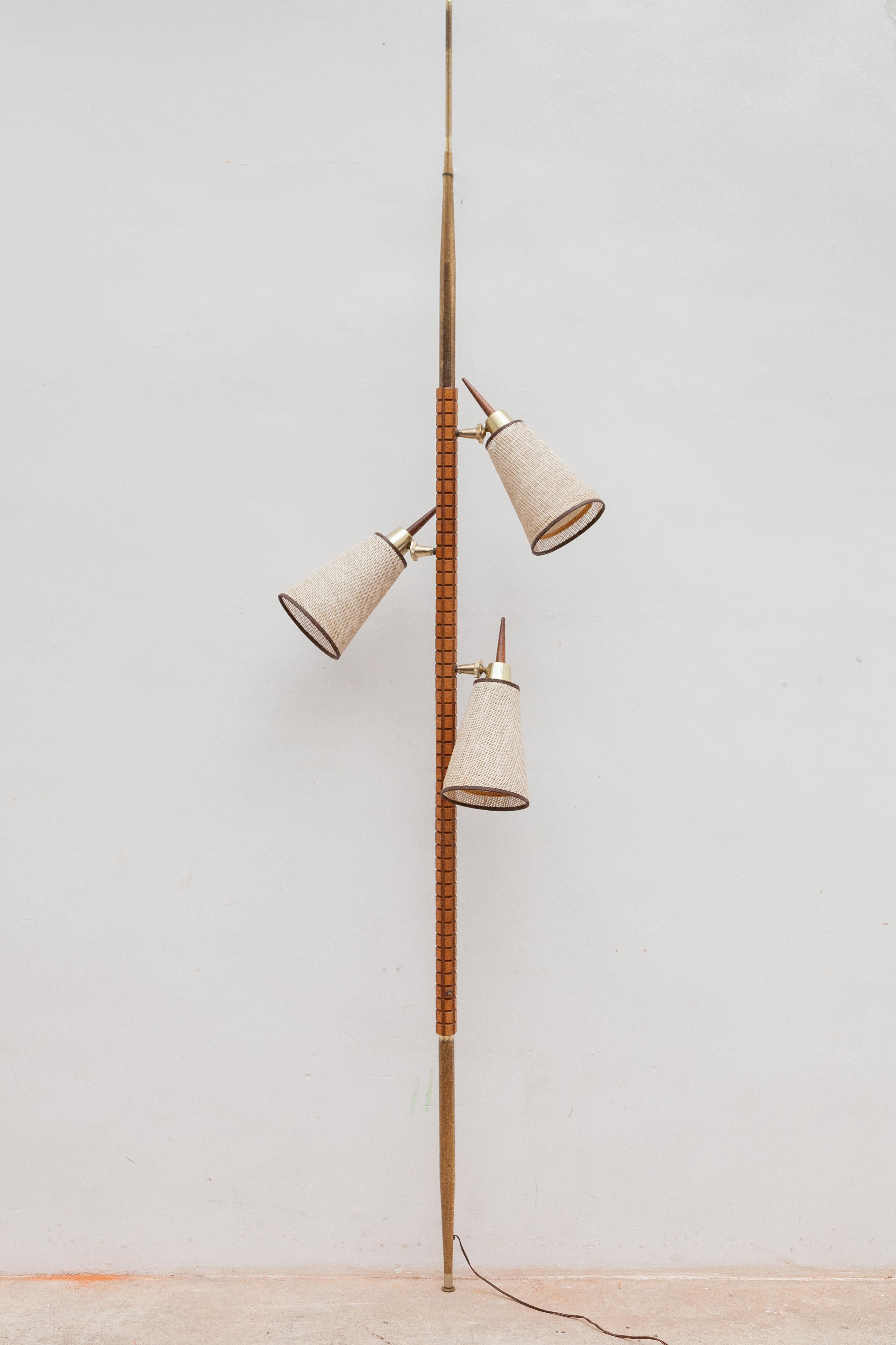 A Mid-Century set of two German Vereinigte Werkstätten München 1950's tension pole lamp. This is an adjustable three-way lamp, featuring solid teak stand with adjustable three linen shades with brass elements and teak handles. Has been tested and is