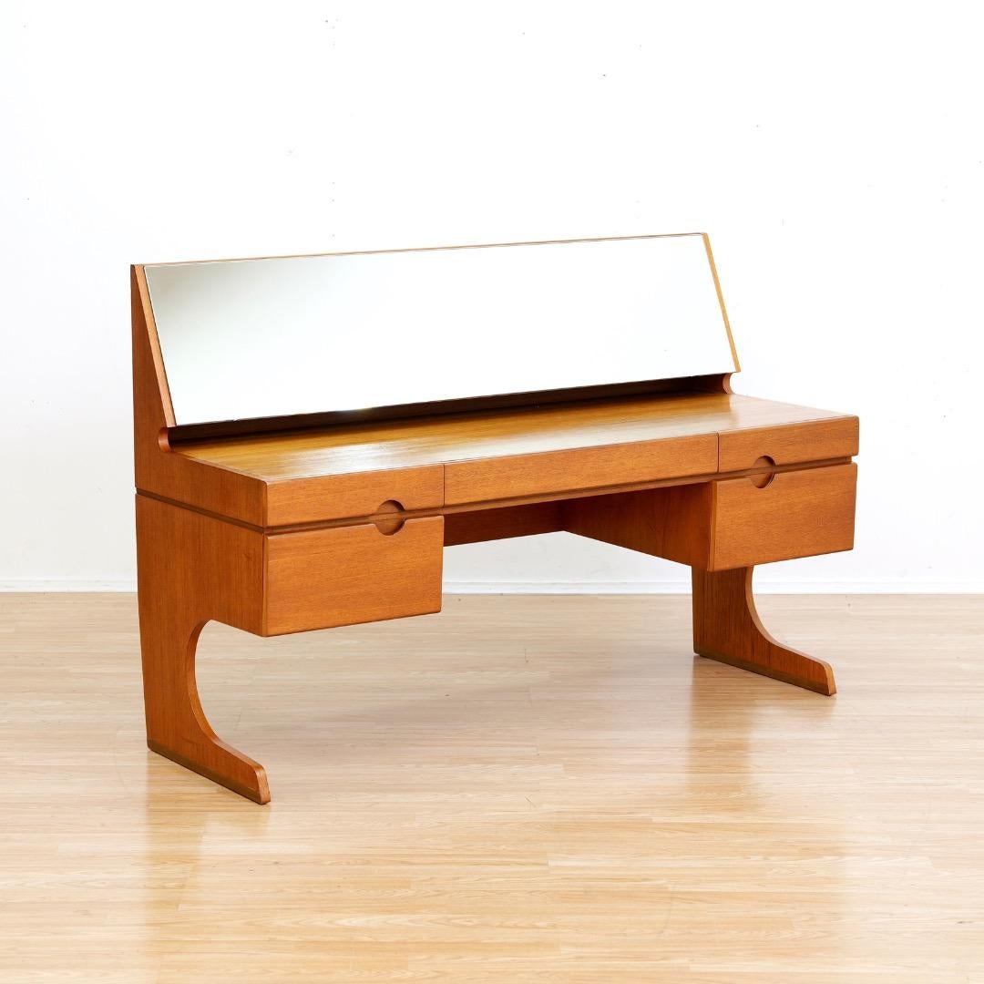 Vanité et tabouret du milieu du siècle par Meredew Furniture. Produit dans les années 1960. Ce meuble-lavabo vintage a des pieds de forme unique et de belles poignées de tiroir. Avec le tabouret assorti, il s'agit d'un ensemble de chambre à coucher