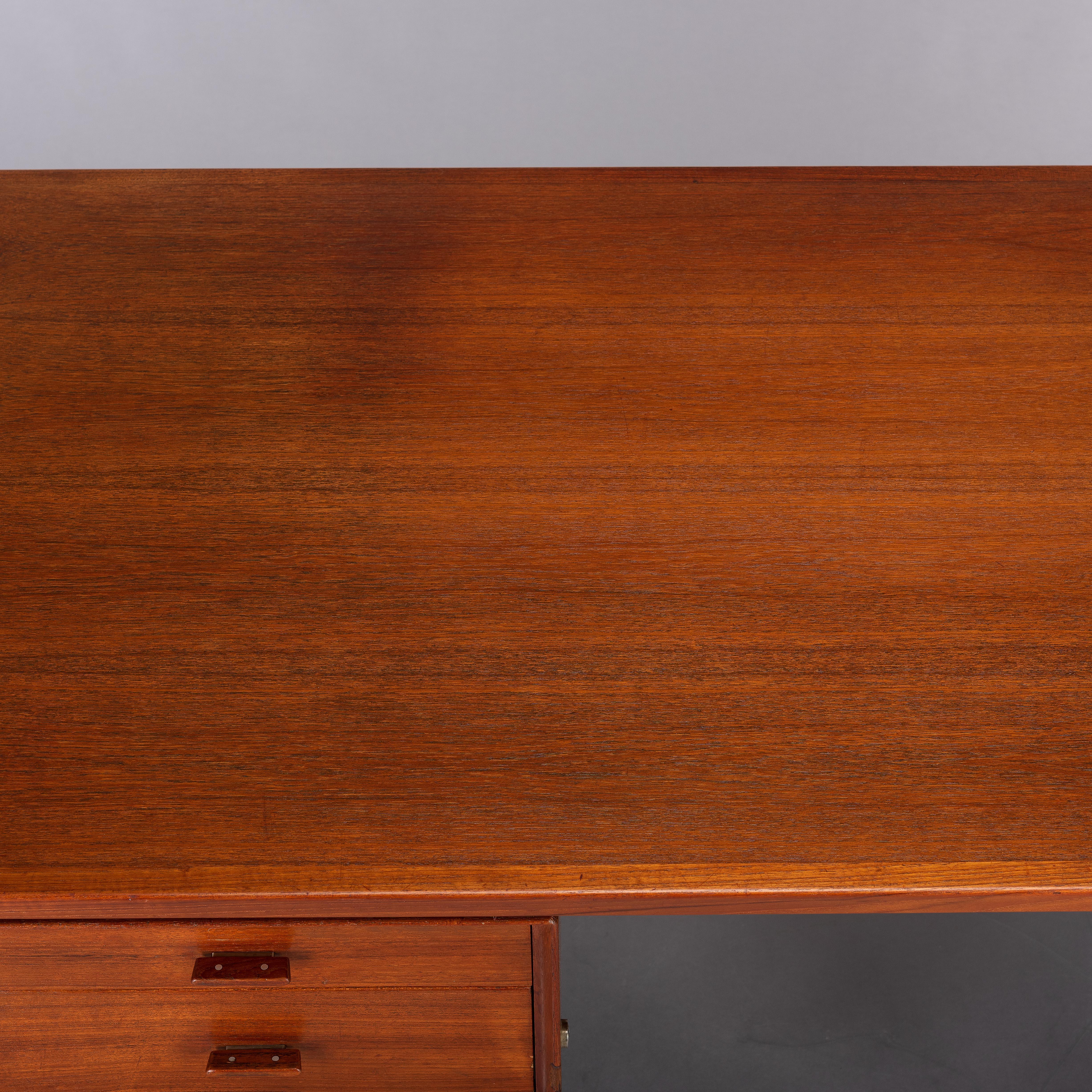 Mid-Century Modern teak writing desk designed by Arne Vodder for Sibast in the sixties. Made as model 207 by Sibast largely with teak veneer although much of the desk has been made with solid teak like the flaps on either end of the desk. The flaps