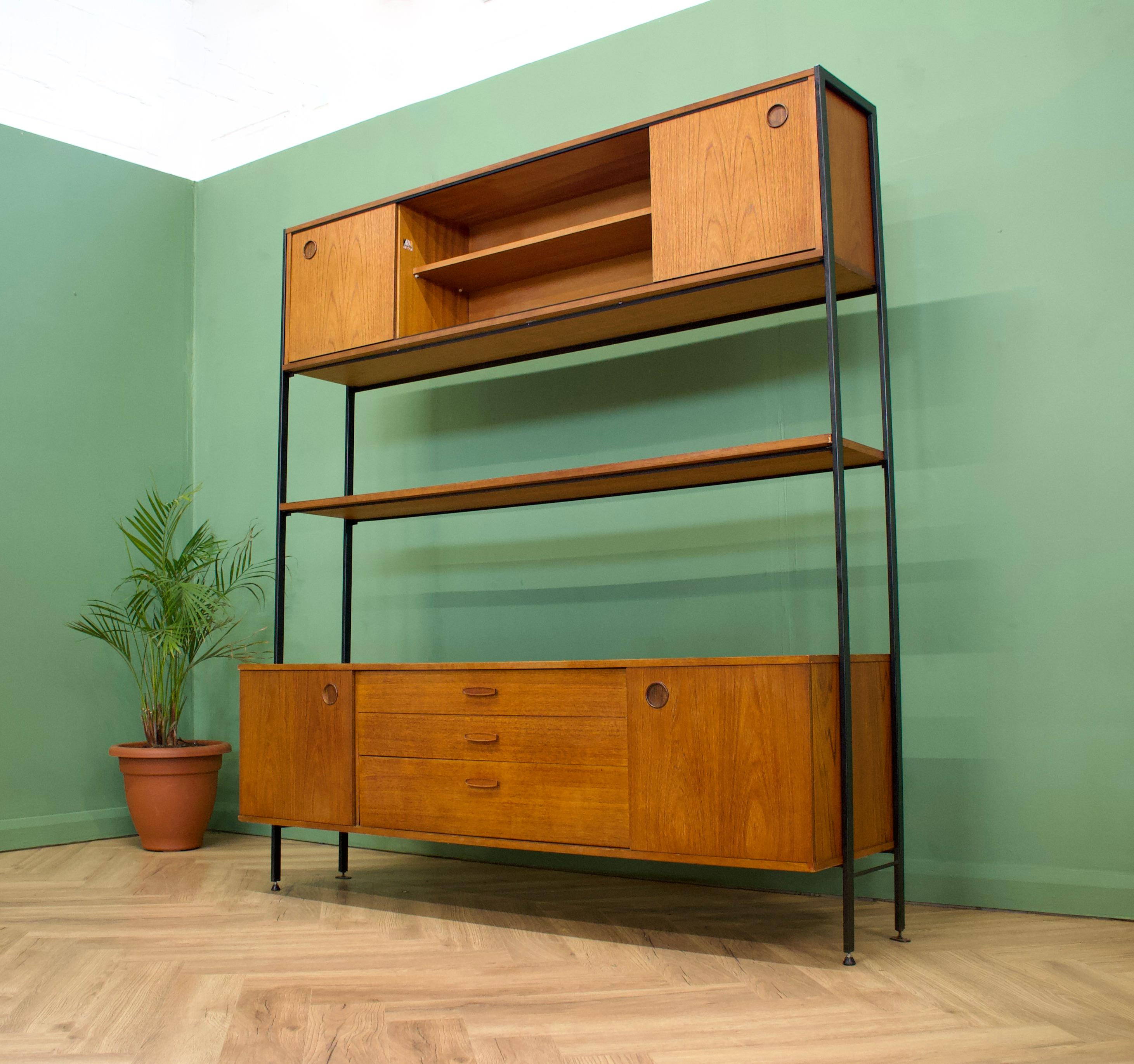 - Mid-Century Modern shelving unit or wall unit
- Manufactured by Avalon in the UK
- Made from teak and teak veneer
- Featuring drawers, shelves and sliding door compartments.