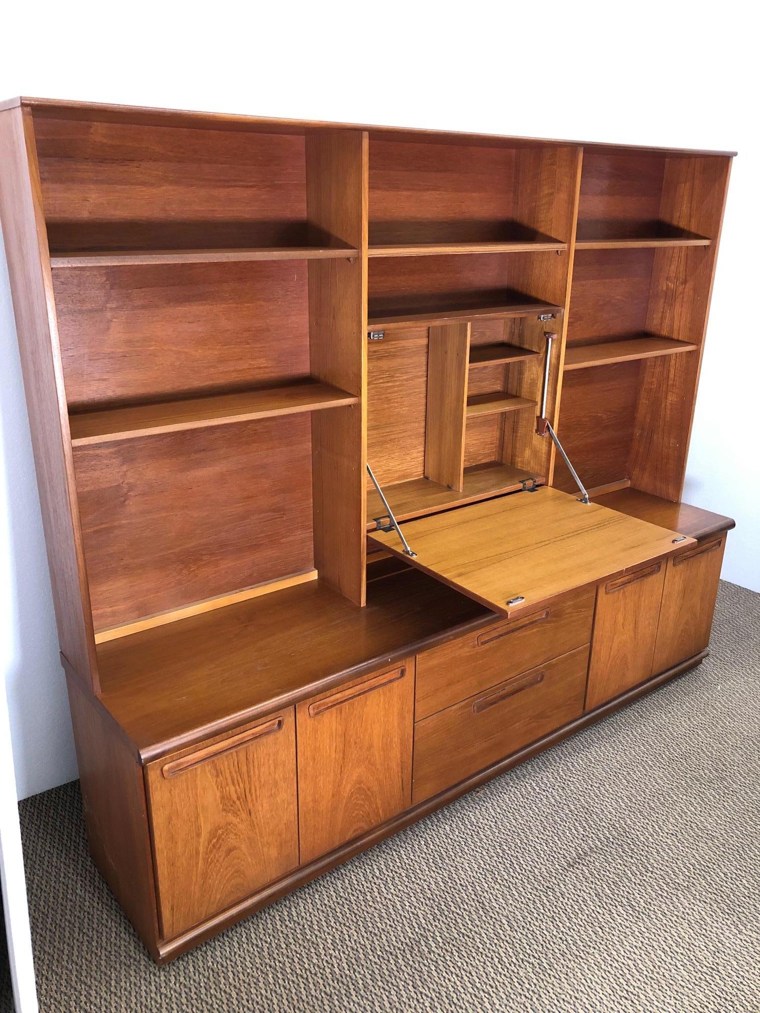 Fantastic teak wall unit by Meredew. Made in England. Original label in top drawer. Featuring a base with 2 drawers and 2 cabinets with adjustable shelves.
The top features a drop down desk and adjustable shelves on the left and the right. The top