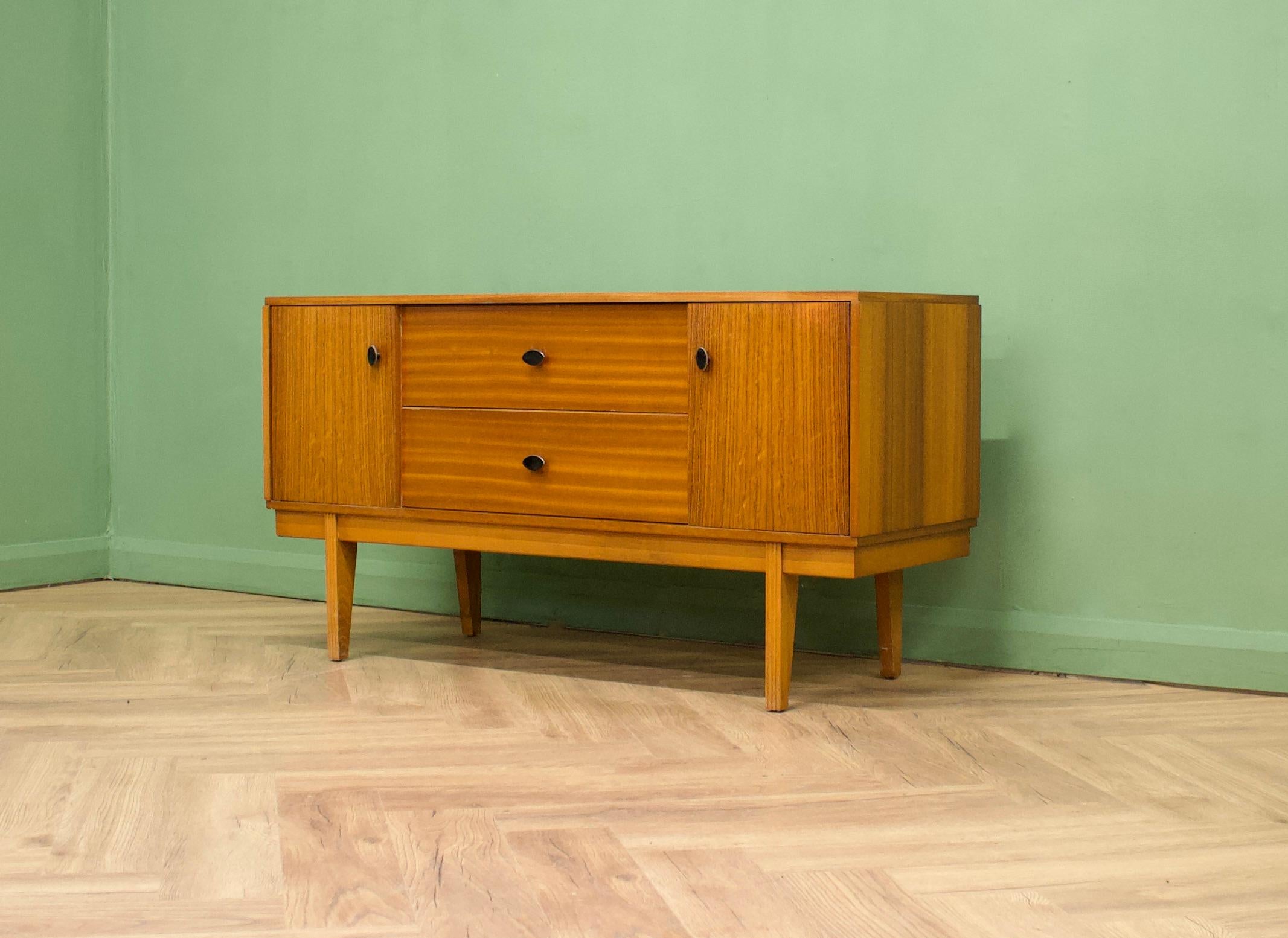 A teak & walnut compact sideboard from Austinsuite London- Circa 1960s

Designed by Frank Guille

It features two drawers and two cupboards