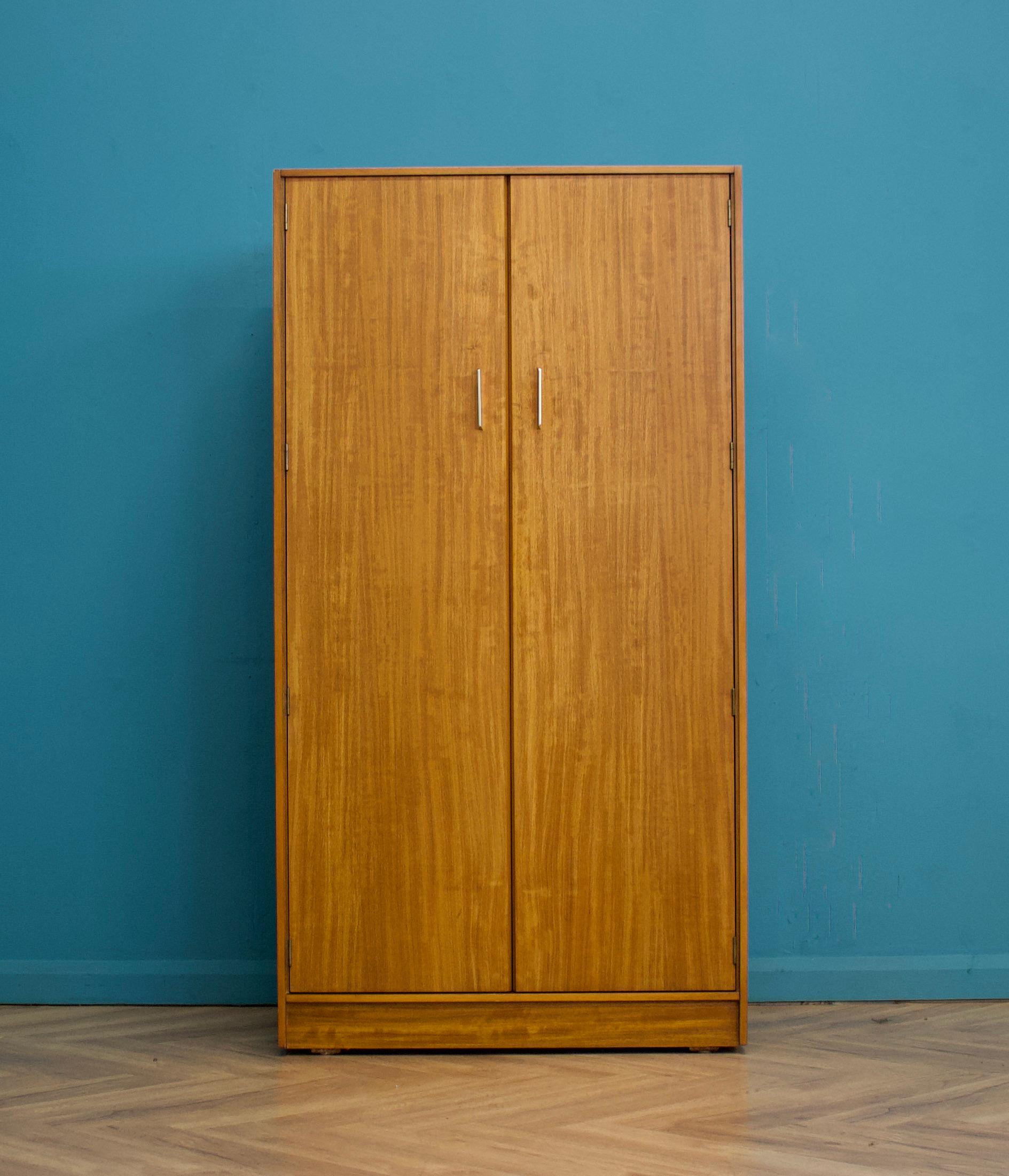 A freestanding double door teak wardrobe
Made during the 1960s


Fitted out with a clothes rail and shelves


Featuring metal handles