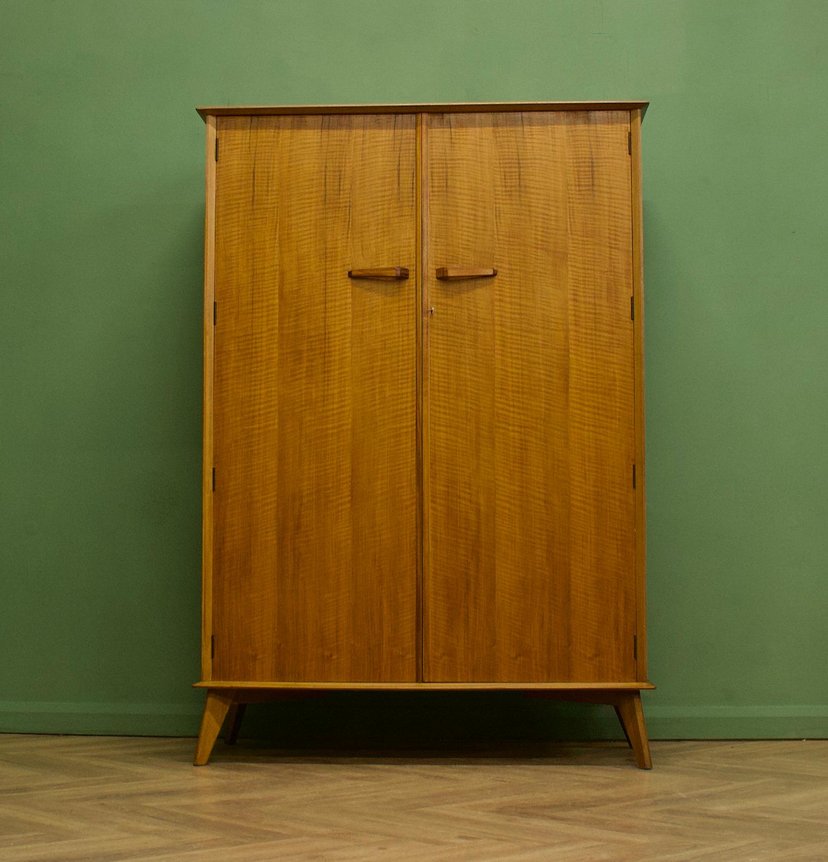 A walnut and teak freestanding wardrobe by Crown Furniture - circa 1960s
Internally there is a rail the full width
The attractive legs are slightly tapered and splayed and the handles are solid wood - complete with a working lock
