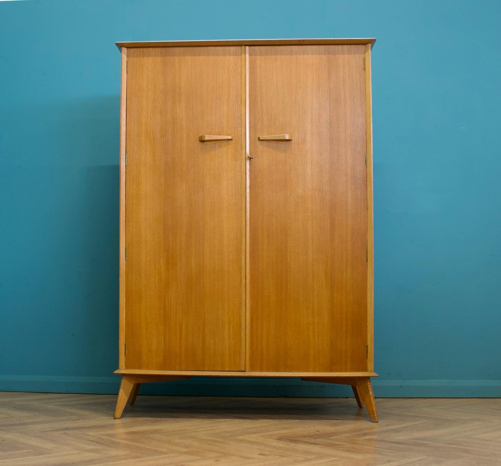 A walnut and teak freestanding wardrobe by Crown Furniture - circa 1960s
Internally there is a rail the full width
The attractive legs are slightly tapered and splayed and the handles are solid wood - complete with a working lock