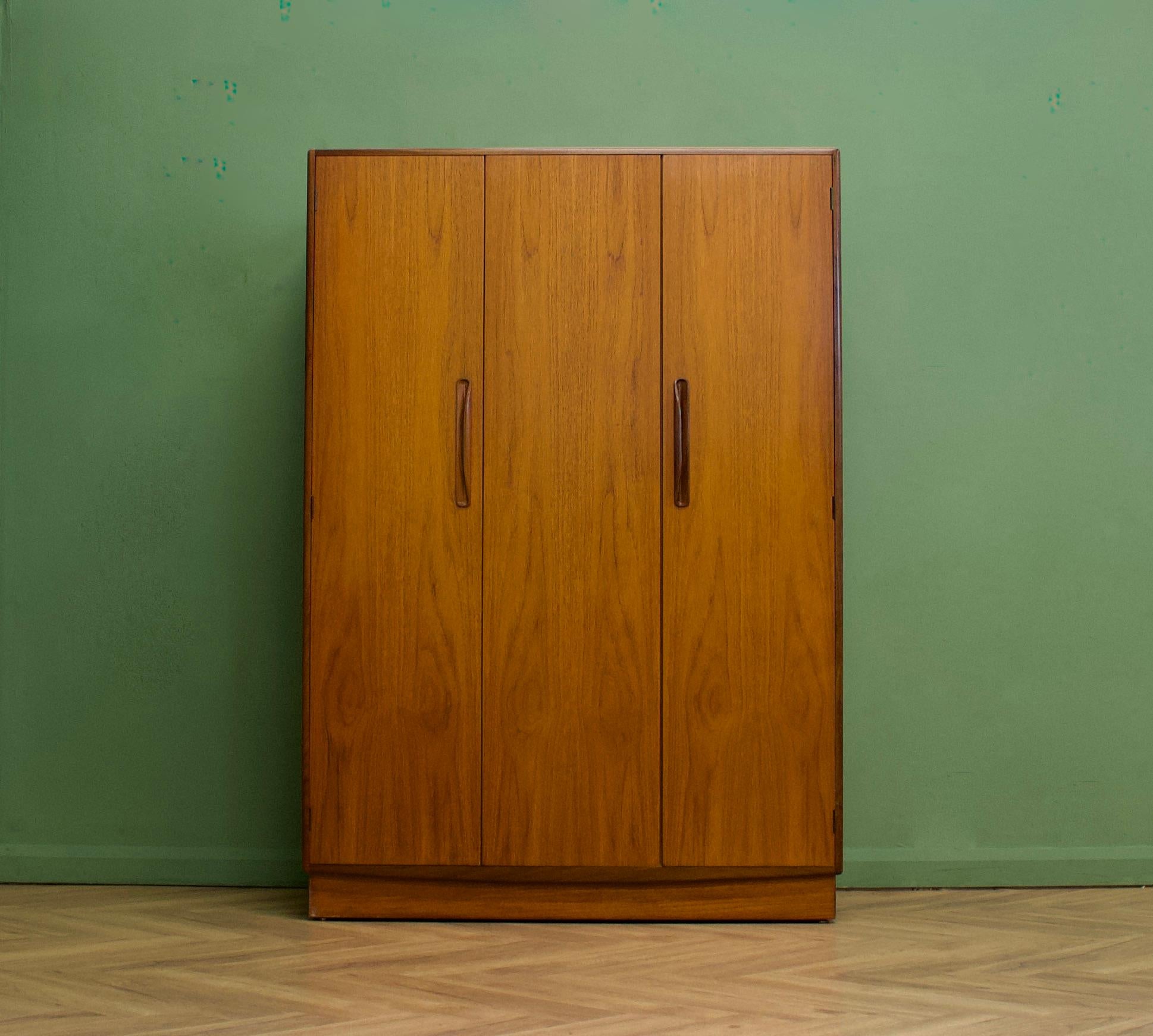 Armoire autoportante en teck à trois portes de G-Plan, de la gamme Fresco - vers les années 1970.


Equipé d'une tringle à linge sur toute la largeur
Le style de cette armoire est minimaliste - avec ses lignes épurées. 


L'armoire à trois portes