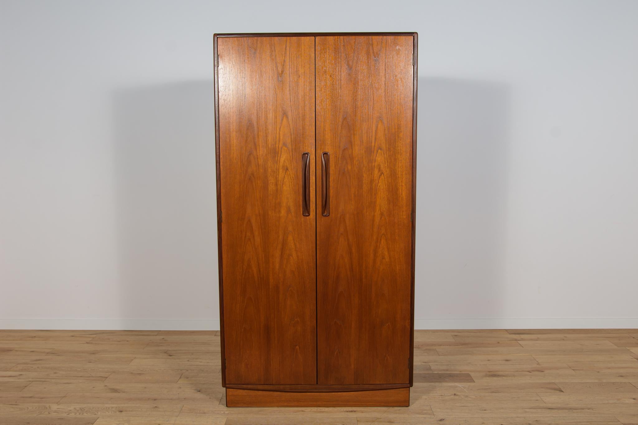 Questo armadio di metà secolo in teak è stato prodotto in Gran Bretagna da G-Plan negli anni Sessanta. Armadio a due ante, all'interno del quale si trovano: corrimano. Gli elementi in teak sono stati ripuliti dal vecchio rivestimento e rifiniti in
