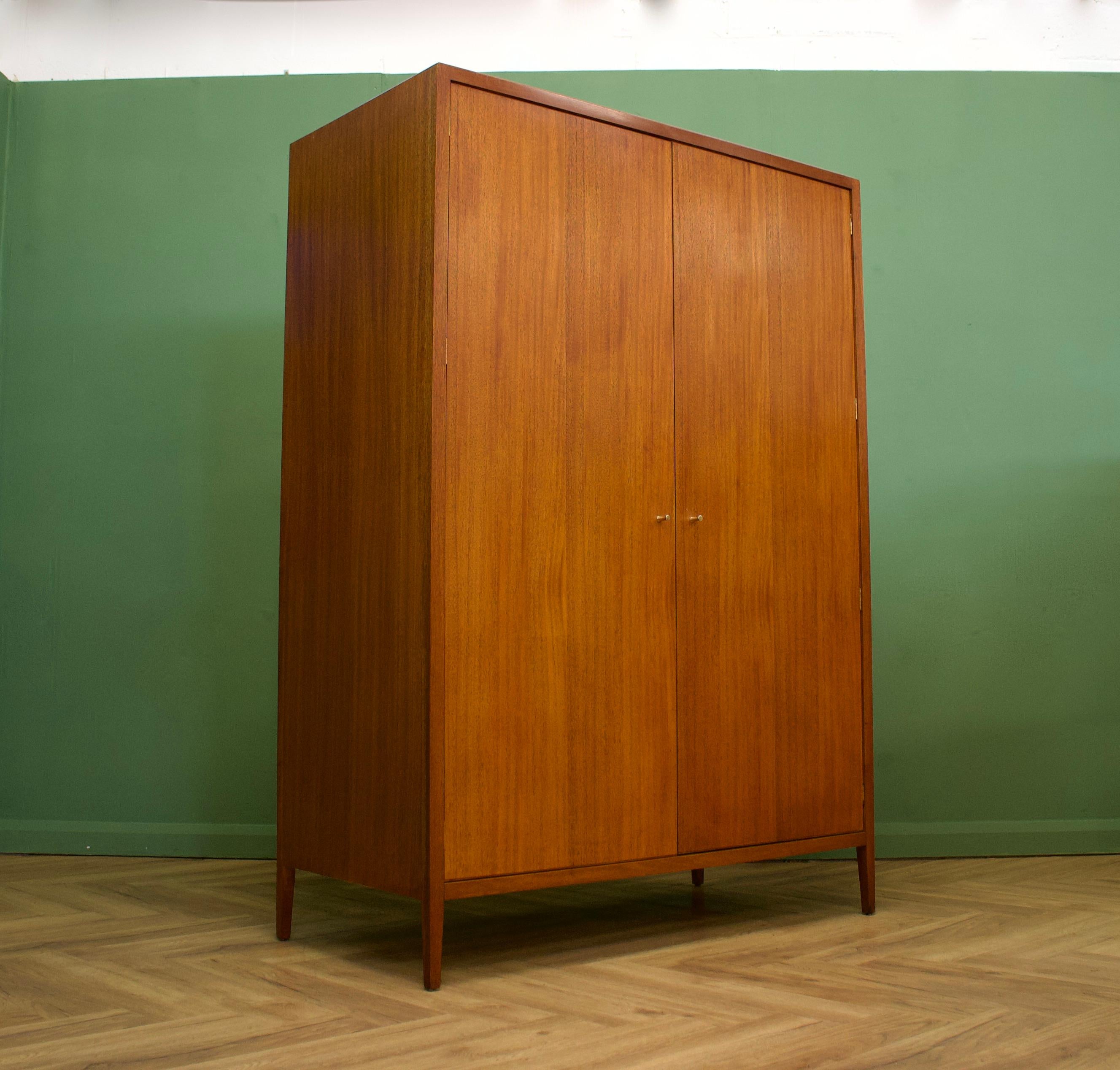 - Mid-Century Modern wardrobe.
- Manufactured by Loughborough in the UK and retailed through Heals department store
- Made from teak & teak veneer
- Featuring a rail the full width of the wardrobe.