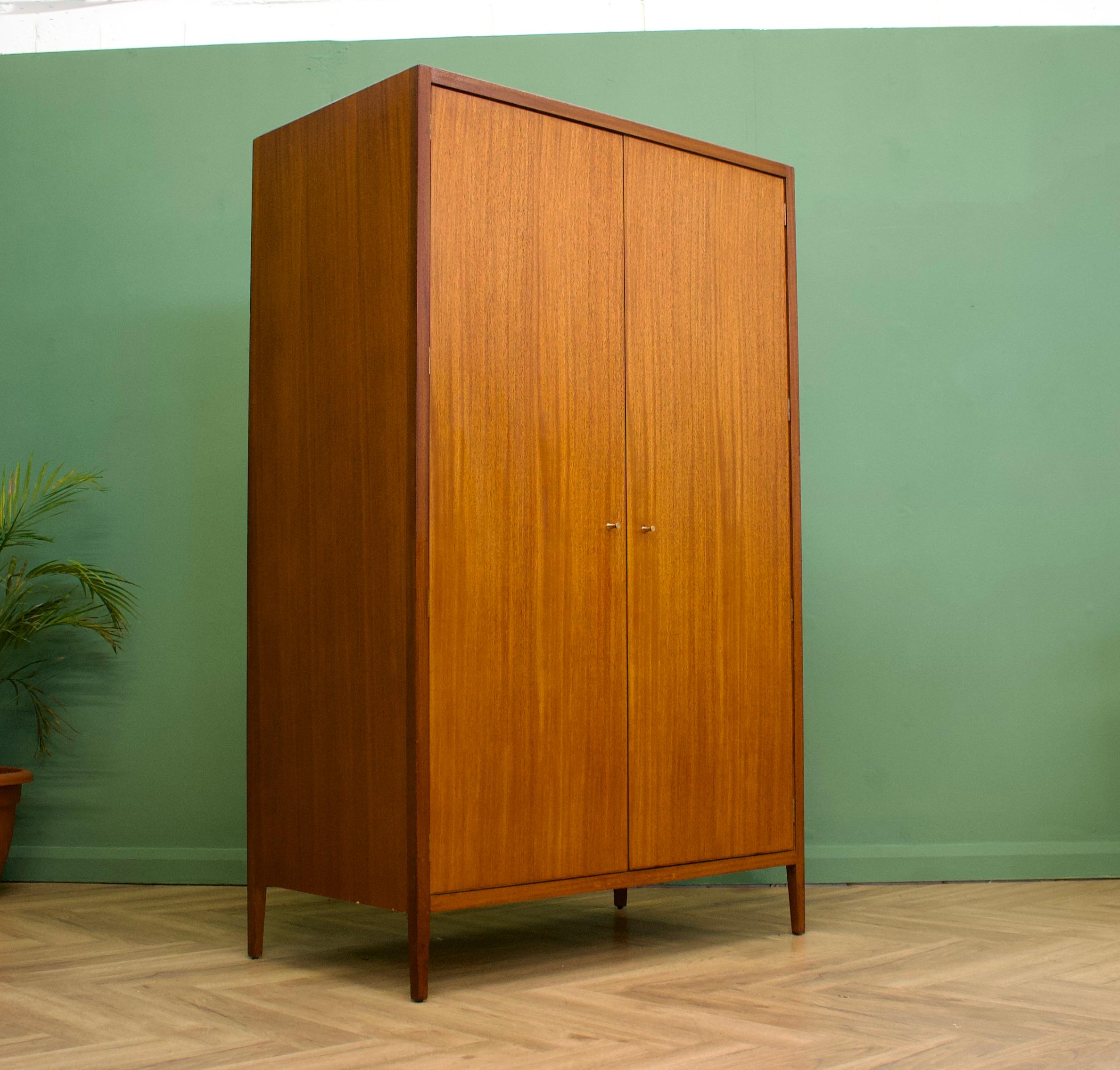 - Mid-Century Modern wardrobe
- Manufactured by Loughborough in the UK and retailed through Heals department store
- Made from Teak & Teak Veneer
- Featuring a hanging rail, drawers and shelves.