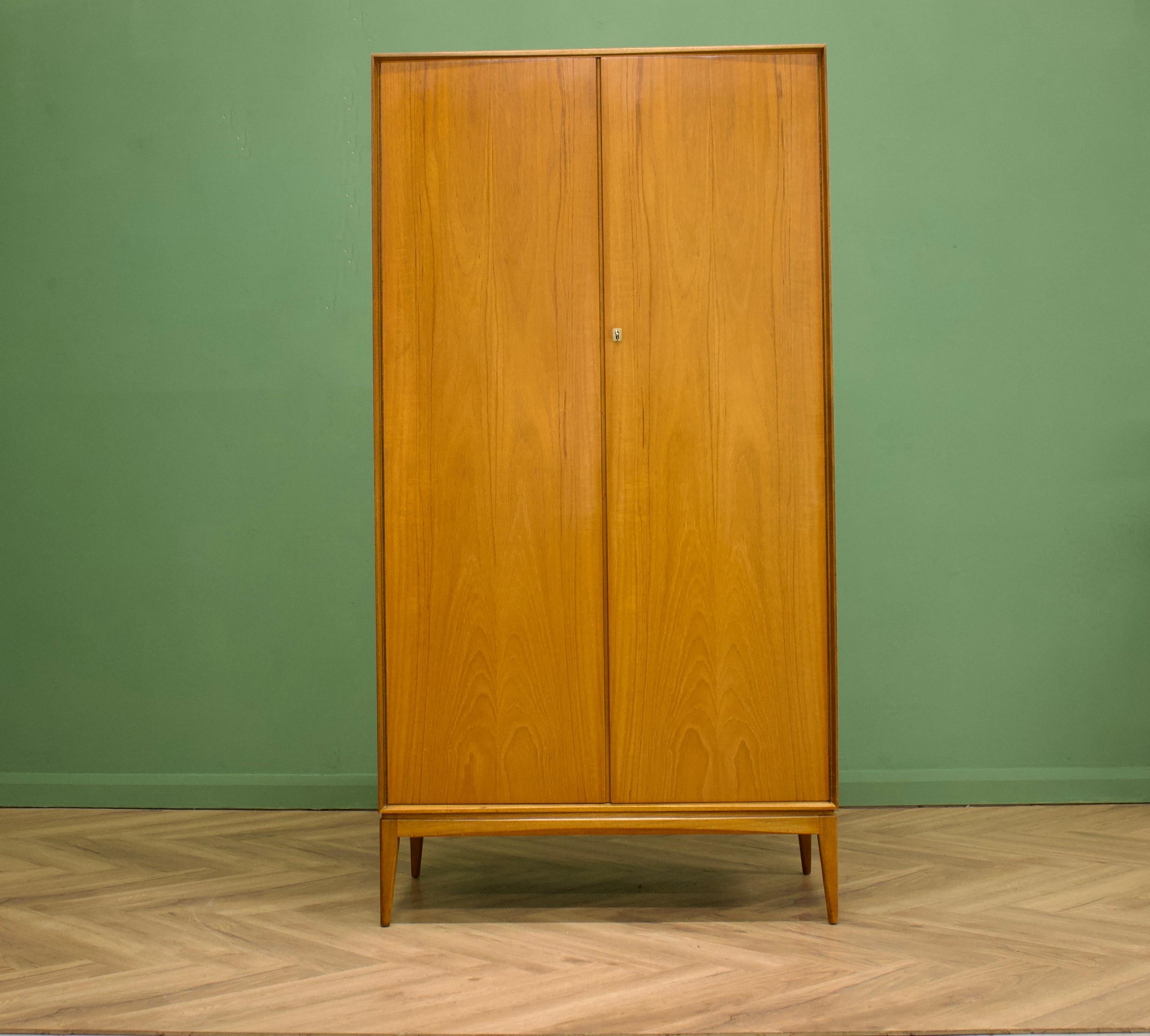 - Mid-Century Modern wardrobe
- Manufactured by McIntosh in the UK
- Made from Teak & Teak Veneer
- Featuring a hanging rail and shelves.