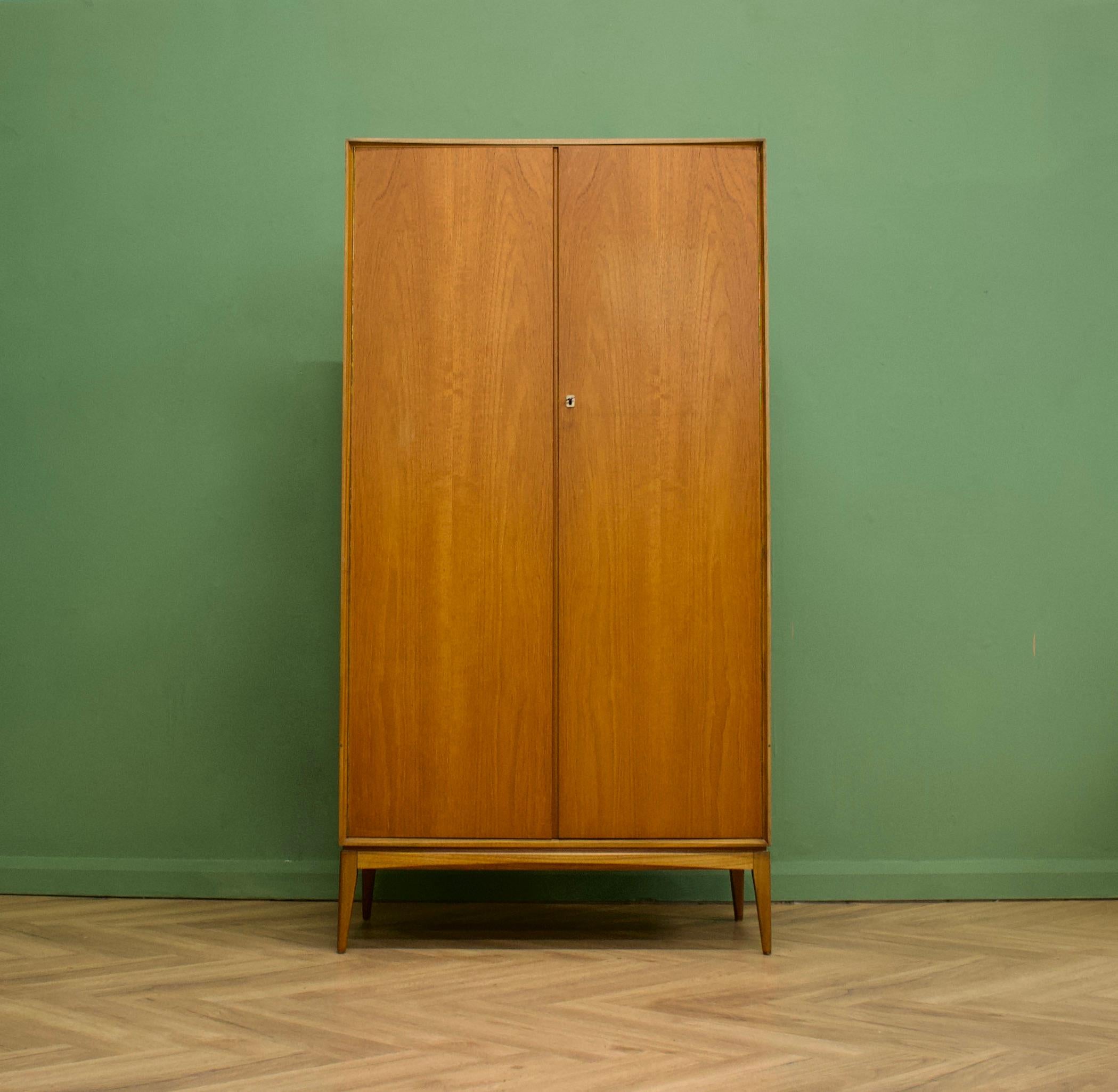 A freestanding double door teak wardrobe from McIntosh - in the Danish modern style
Made during the 1960s

Fitted out with a clothes rail and fixed shelving for ample storage in such a compact piece
The style of this wardrobe is minimalist -