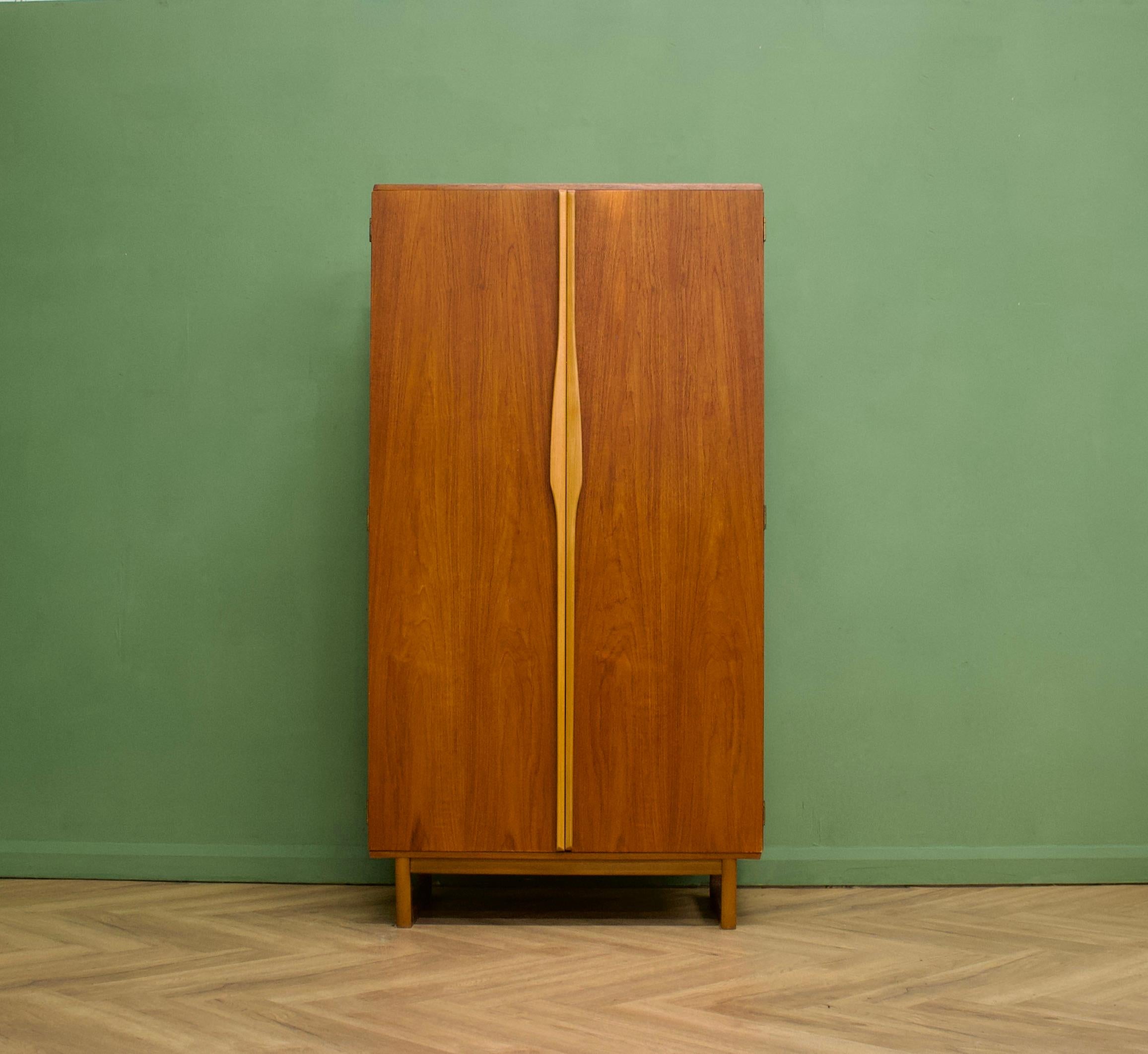 A freestanding two door teak wardrobe from Stonehill Furniture -  in the Danish modern style
Made during the 1960s


Fitted out with a clothes rail to one side, shelves and a compartment to the other


This wardrobe flat packs


The matching larger