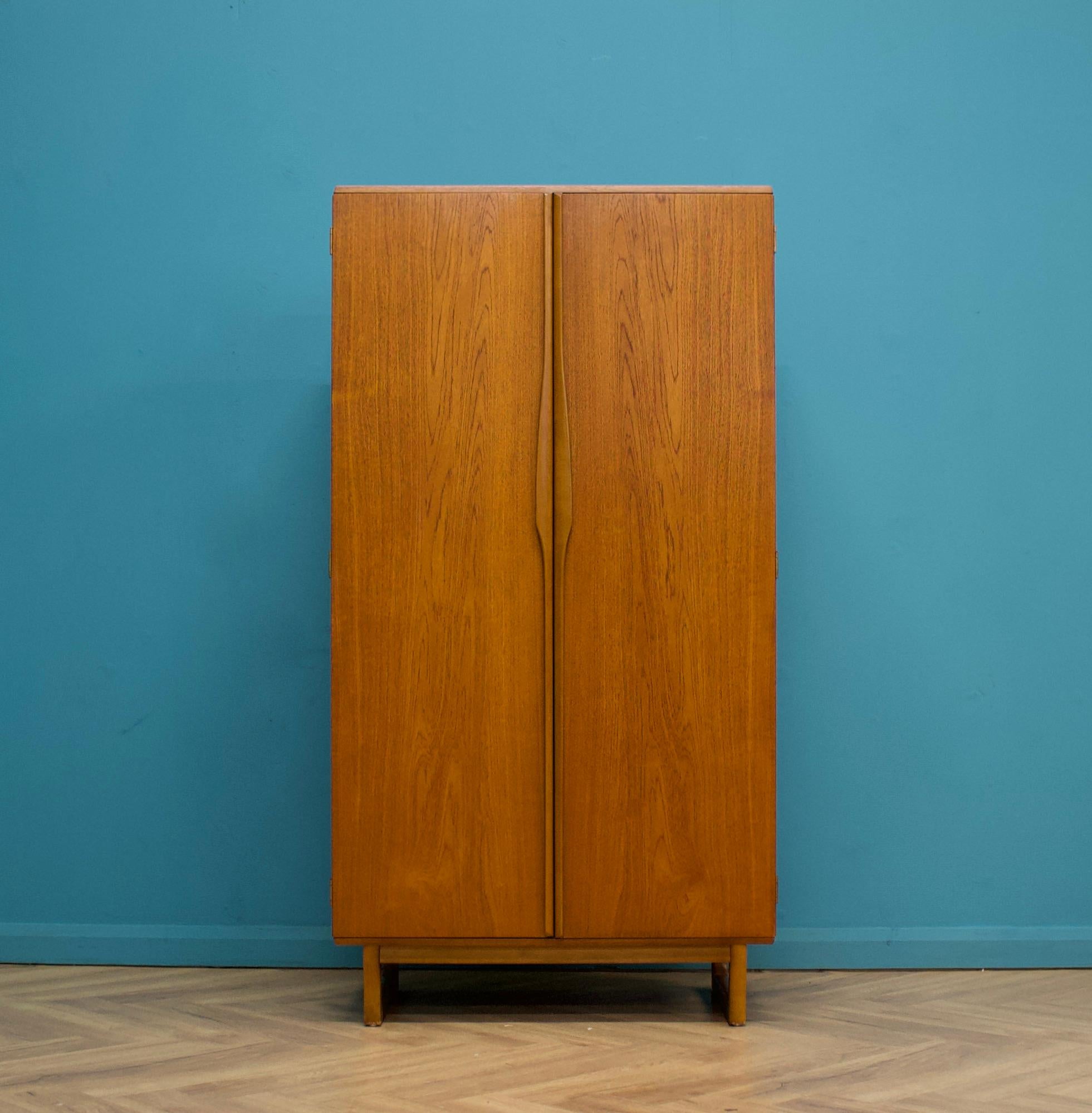 A freestanding two door teak wardrobe from Stonehill Furniture -  in the Danish modern style
Made during the 1960s


Fitted out with a clothes rail to one side, shelves and a compartment to the other


This wardrobe flat packs


