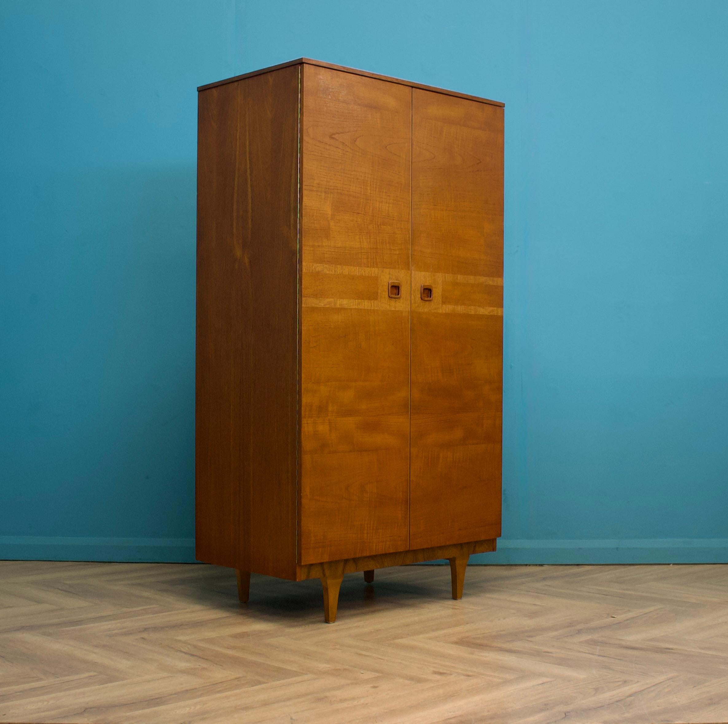 Un armario independiente de teca de doble puerta de Stonehill
Fabricado en los años 60


Equipada con barra de colgar, cajones y estantes
El estilo de este armario es bastante minimalista, con sus líneas limpias y tiradores empotrados.


Este