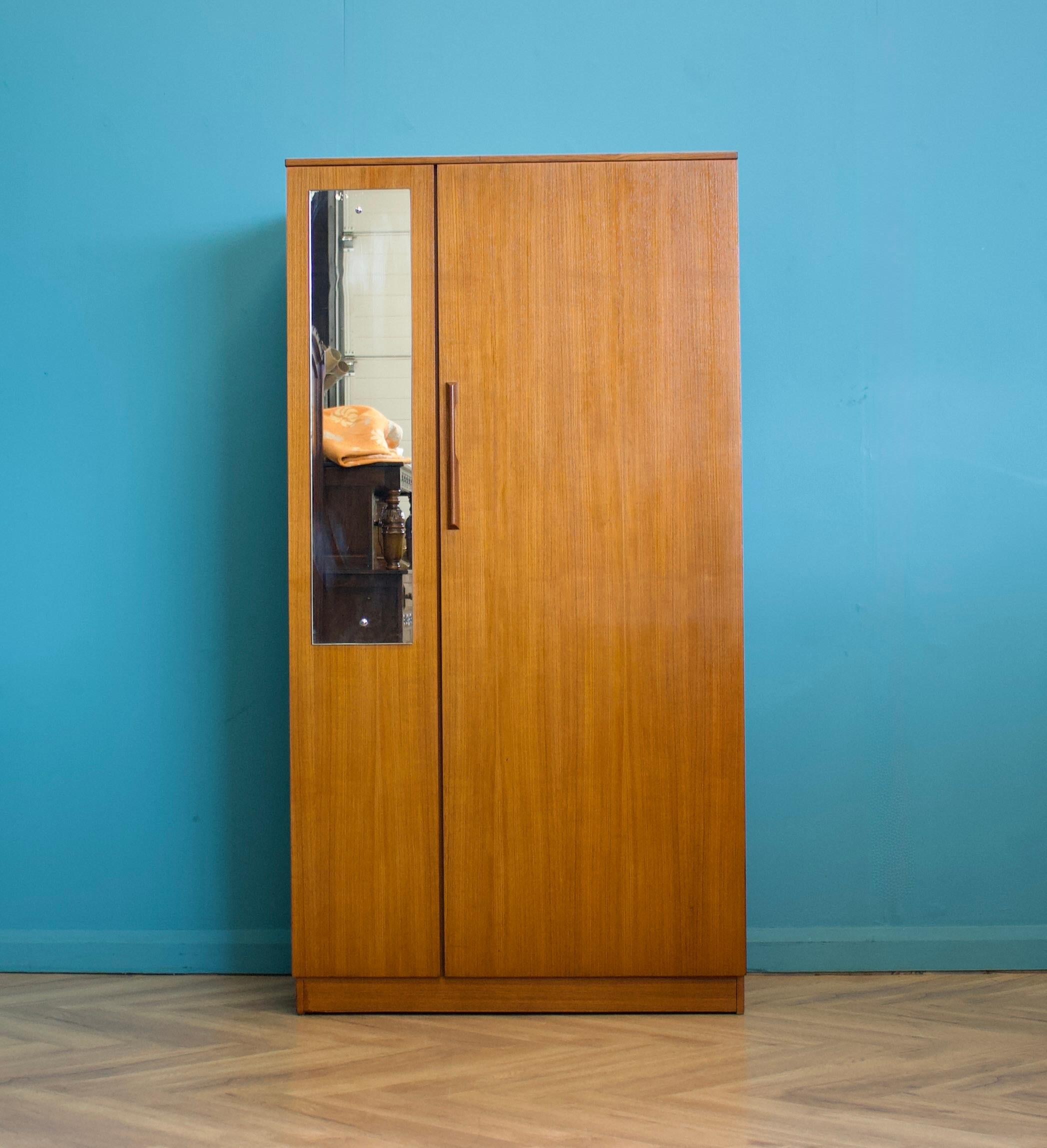 Un armadio freestanding a due ante in teak di Avalon
Realizzato negli anni '60

Dotato di appendiabiti
Lo stile di questo guardaroba è piuttosto minimalista, con le sue linee pulite.
C'è uno specchio pieno su una porta

L'armadio più grande abbinato