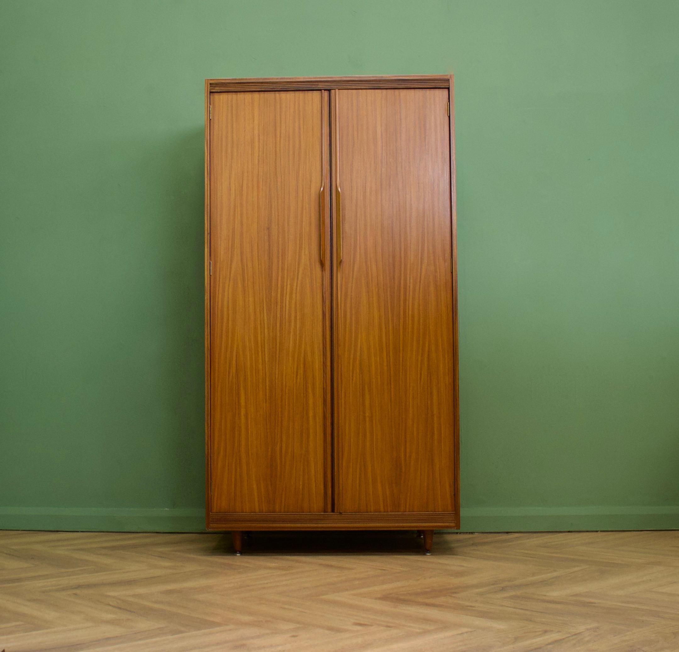 A freestanding double door teak wardrobe from White & Newton-  in the Danish modern style
Made during the 1960s


Fitted out with two clothes rails, drawers and fixed shelving for ample storage in such a compact piece
The style of this wardrobe is
