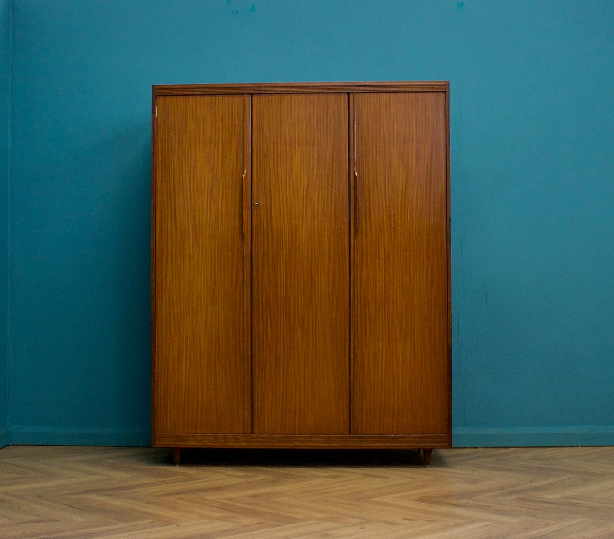 A freestanding three door teak wardrobe from White & Newton- in the Danish modern style
Made during the 1960s

Fitted out with a clothes rail, drawers, a compartment and shelving for ample storage in such a compact piece
The style of this wardrobe