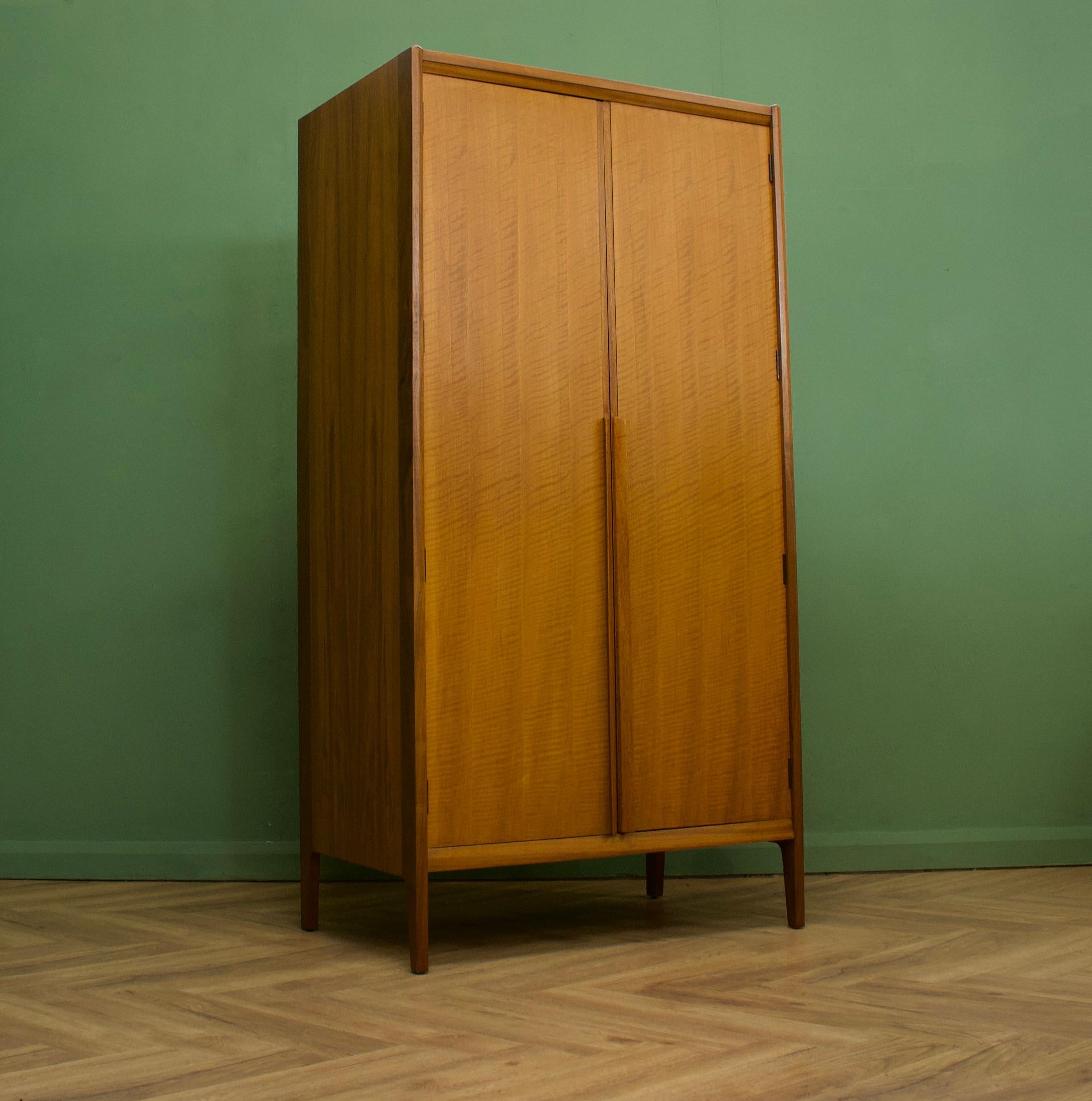A freestanding double door walnut & teak wardrobe from Younger-  in the Danish modern style
Made during the 1960s


Fitted out with a clothes rail and fixed shelving for ample storage in such a compact piece
The style of this wardrobe is quite