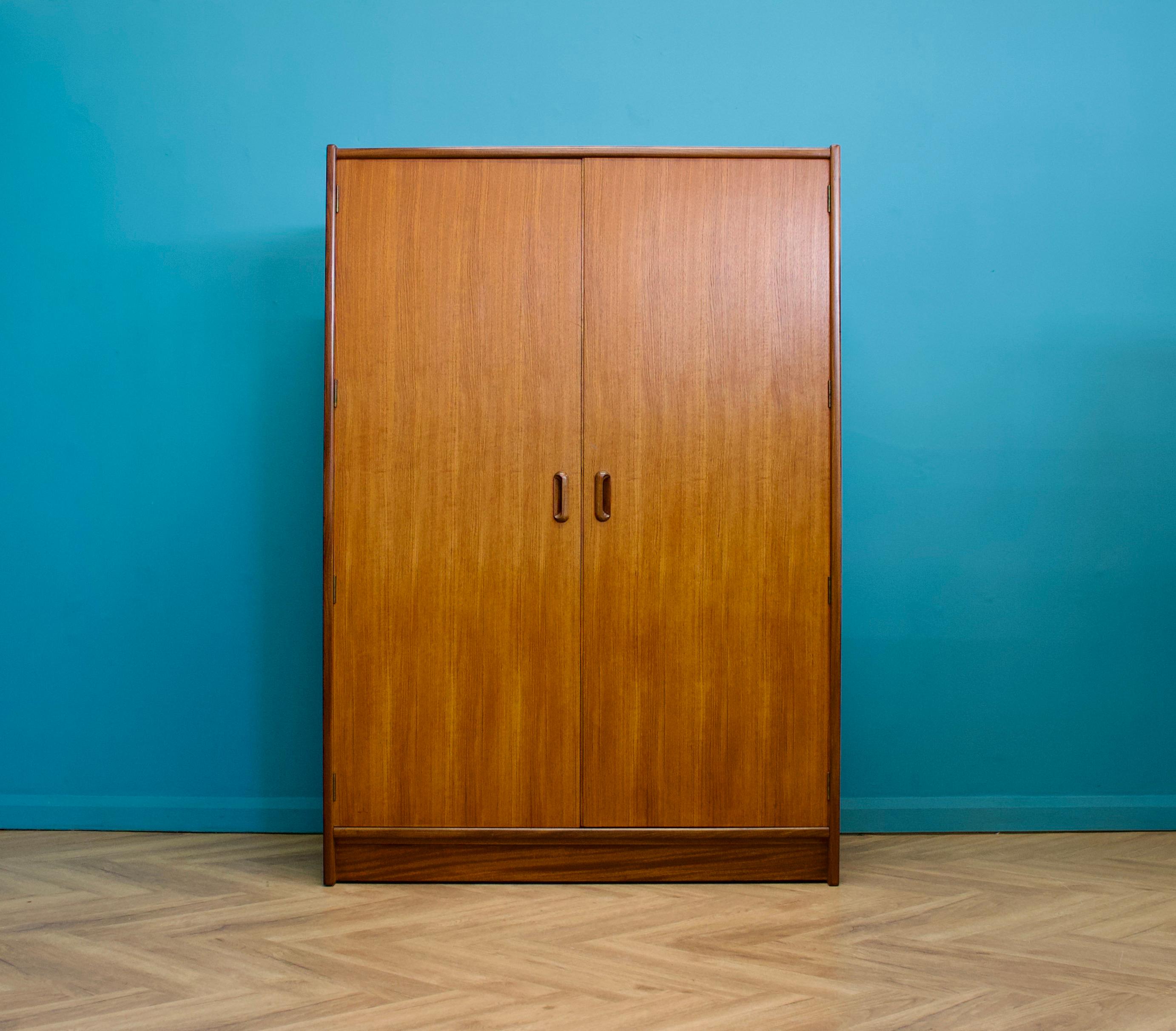 A freestanding double door teak wardrobe from Younger Made during the 1960s
Fitted out with a clothes rail
Featuring solid teak inset handles