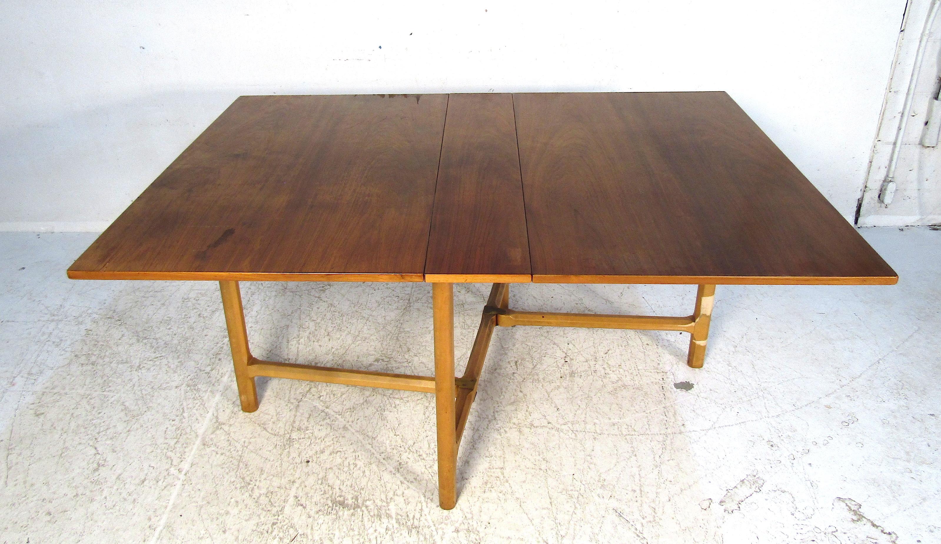 This elegant midcentury drop-leaf table is both functional and beautiful. Able to be stored in almost any spot of the house this table is perfect for smaller apartments or homes while still allowing for a larger dining experience when needed. Please