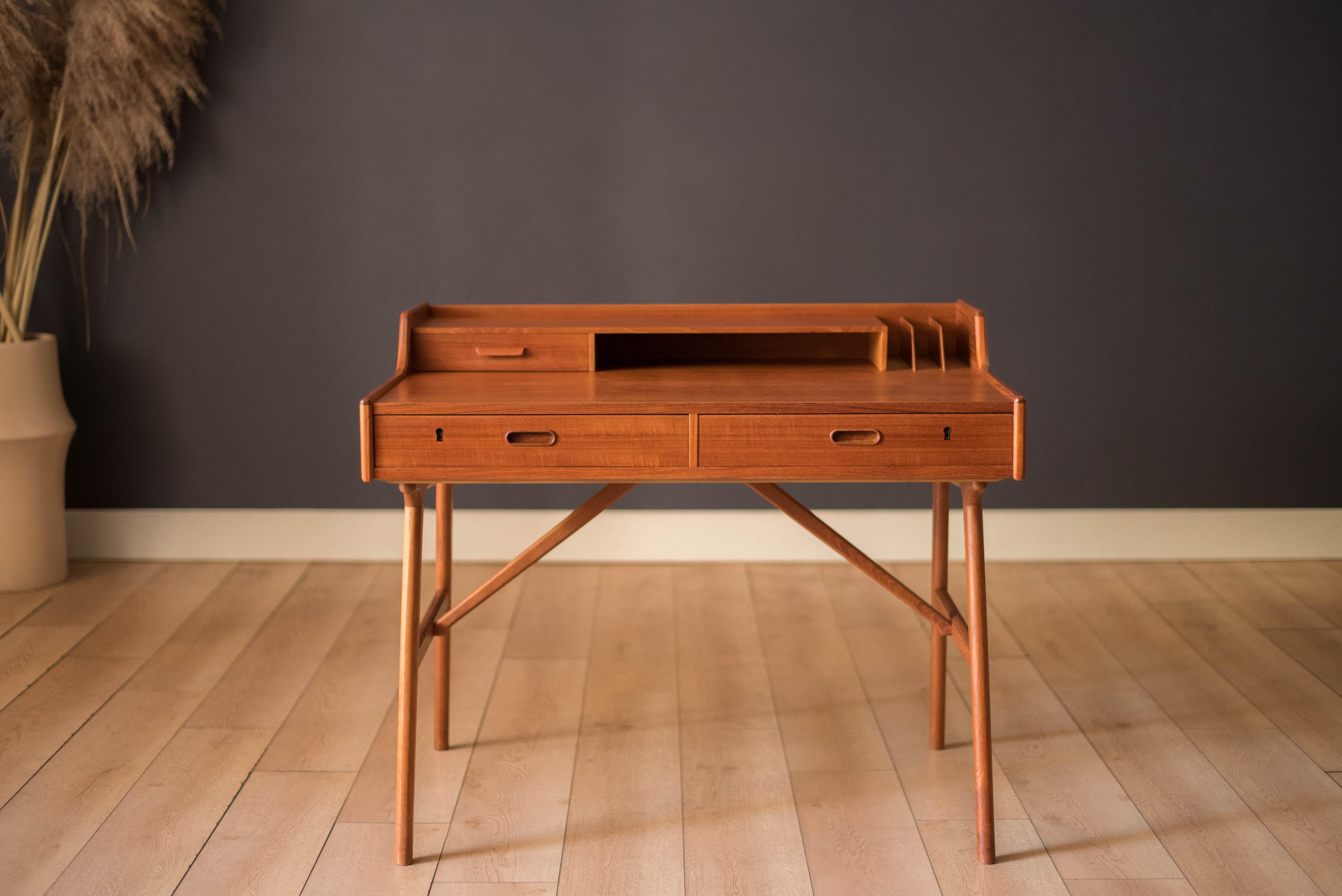 Scrittoio danese vintage in teak disegnato da Arne Wahl Iversen per Vinde Møbelfabrik, Danimarca. Questo pezzo versatile è caratterizzato da esclusive gambe strombate con traverse di sostegno. Offre un ampio spazio di archiviazione, con tre cassetti