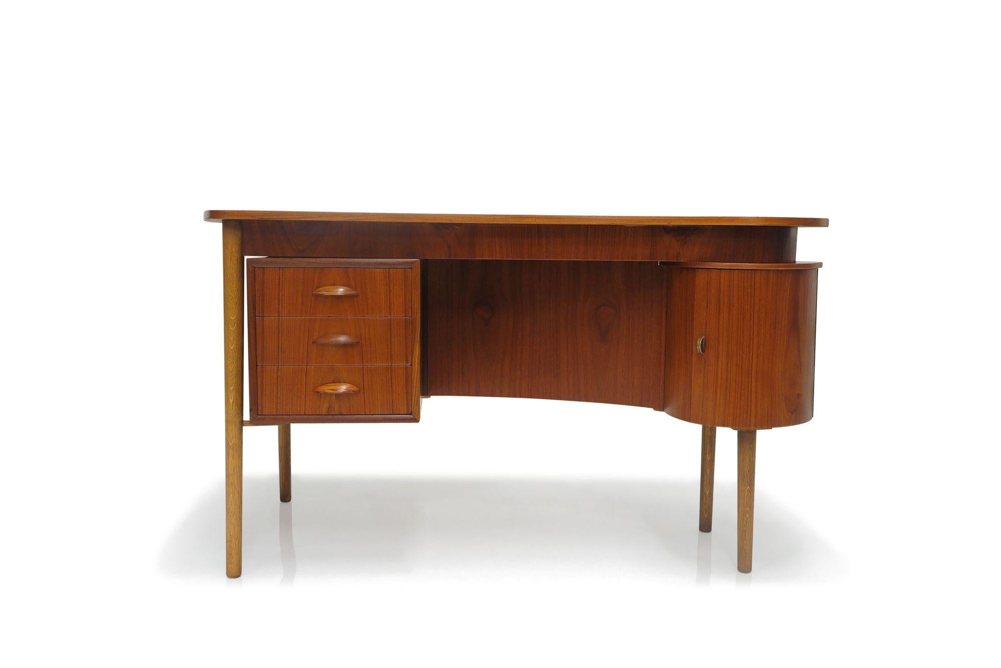 Mid-century teak desk designed by Kai Kristiansen, circa 1959, in Denmark.
The desk is crafted of teak, with a curved top surface, a series of three drawers with carved pulls, a right-side cabinet with a shelf, and a book shelf on the back side of