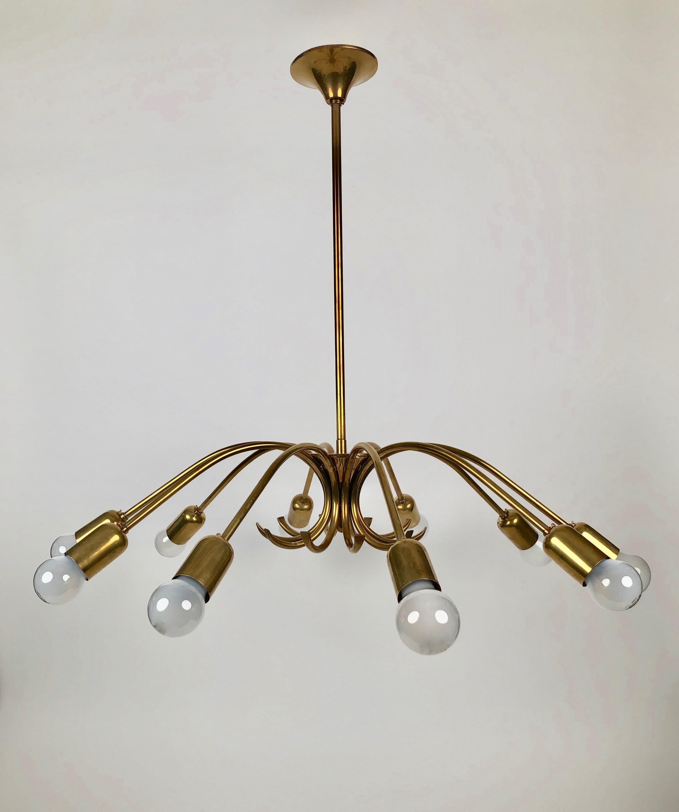 Un bellissimo lampadario a 10 bracci in ottone di Rupert Nikoll, risalente alla metà del secolo scorso.
Qui abbiamo un'eccellente maestria  con bellissime forme realizzate in Austria.